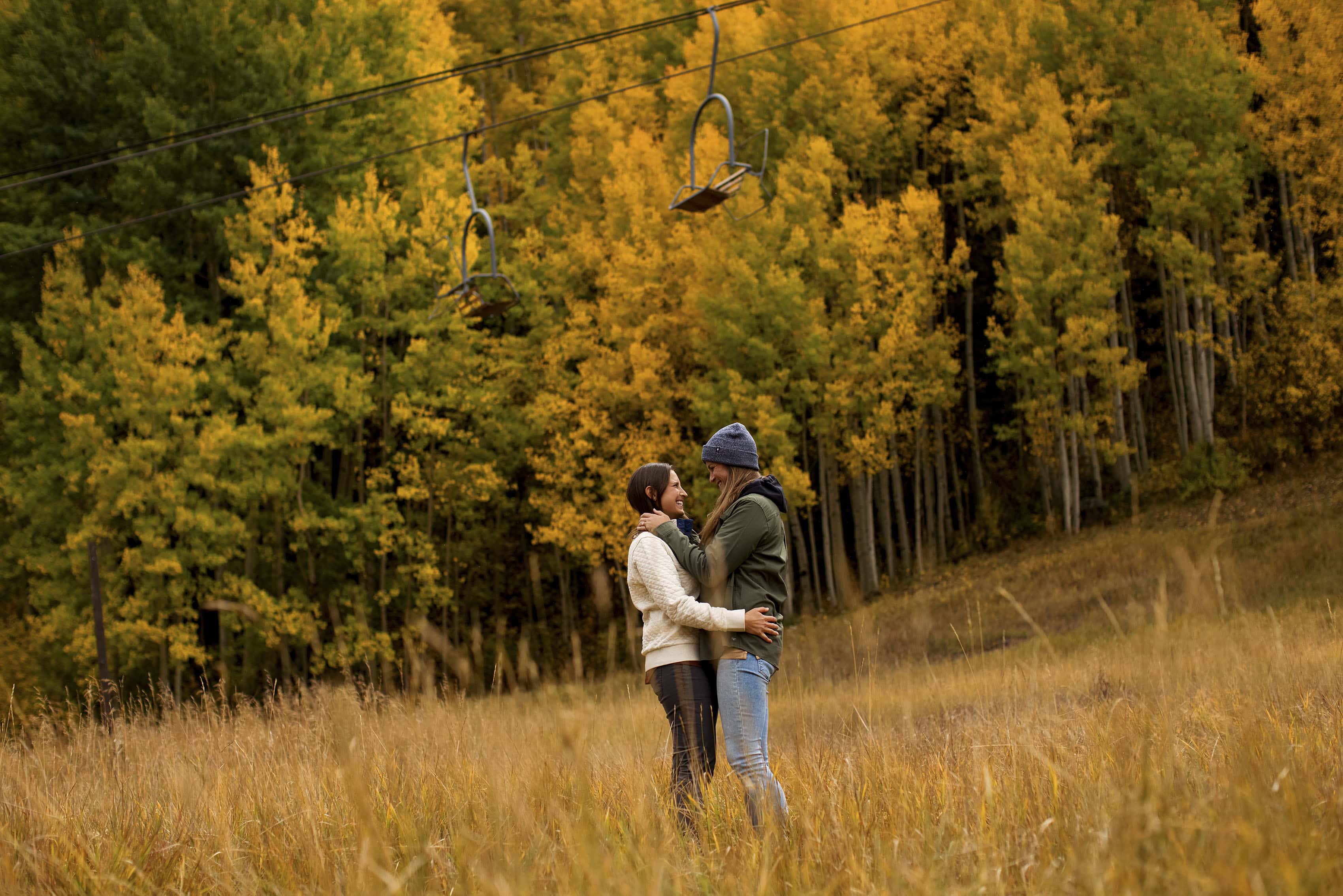 A couple hugs each other near the Coonskin lift during their fall engagement at Telluride Ski Resort