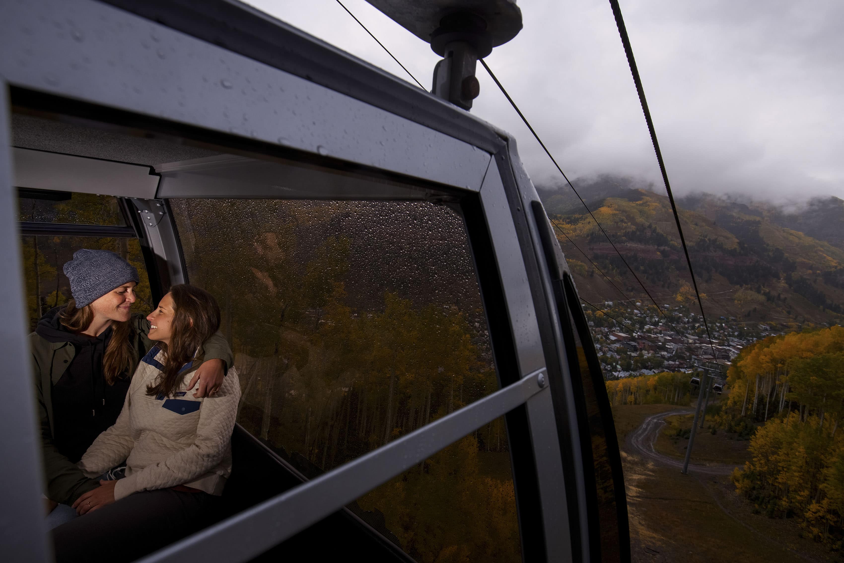 Cait and Anna ride the gondola in Telluride during their engagement session