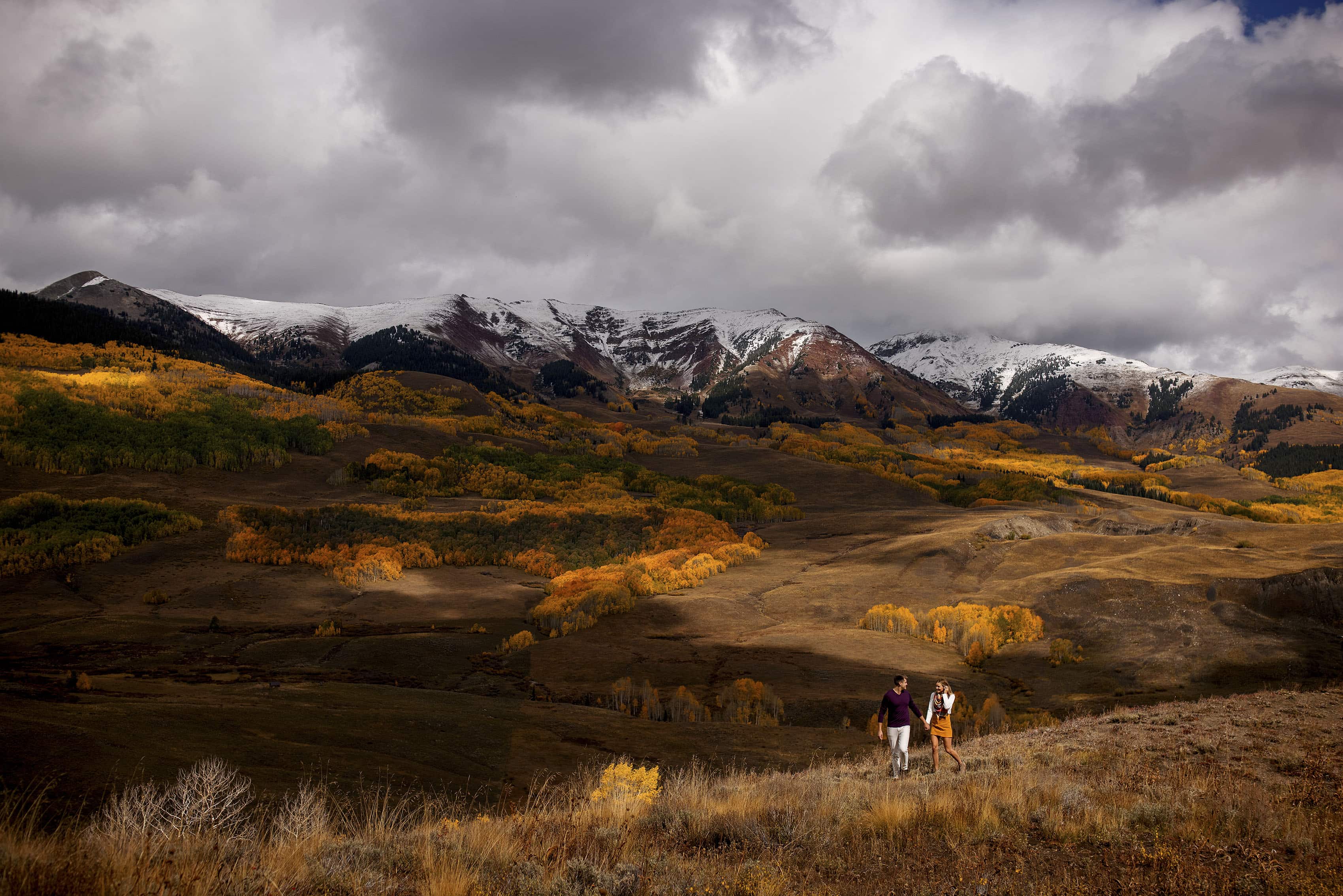 A couple walks along the ridge near White Rock Mountain in Crested Butte during their fall photo session