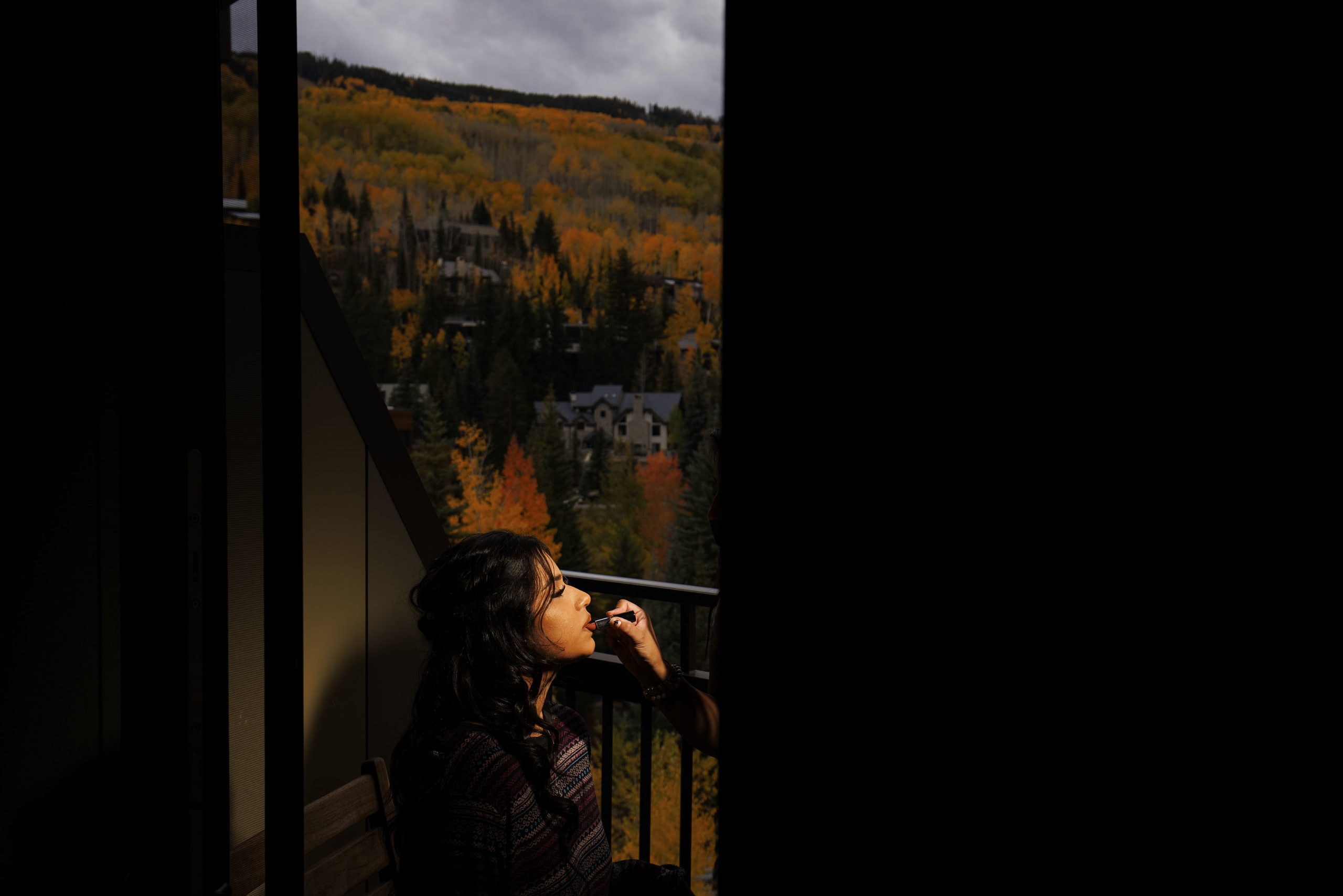 The bride applies lipstick on the balcony at the Four Seasons Resort and Residences Vail