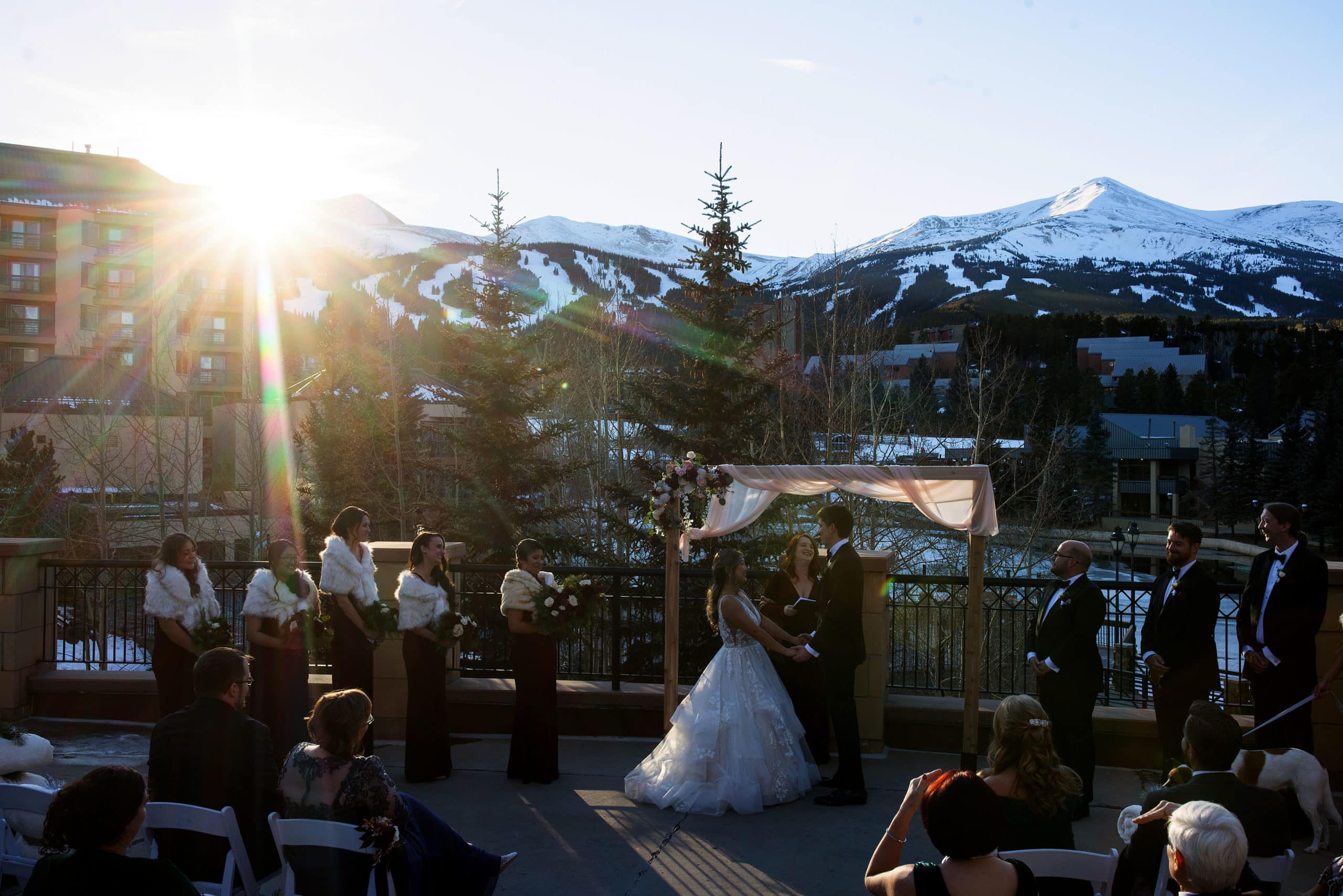 The sun sets over the mountain during a winter wedding ceremony at Main Street Station in Breckenridge