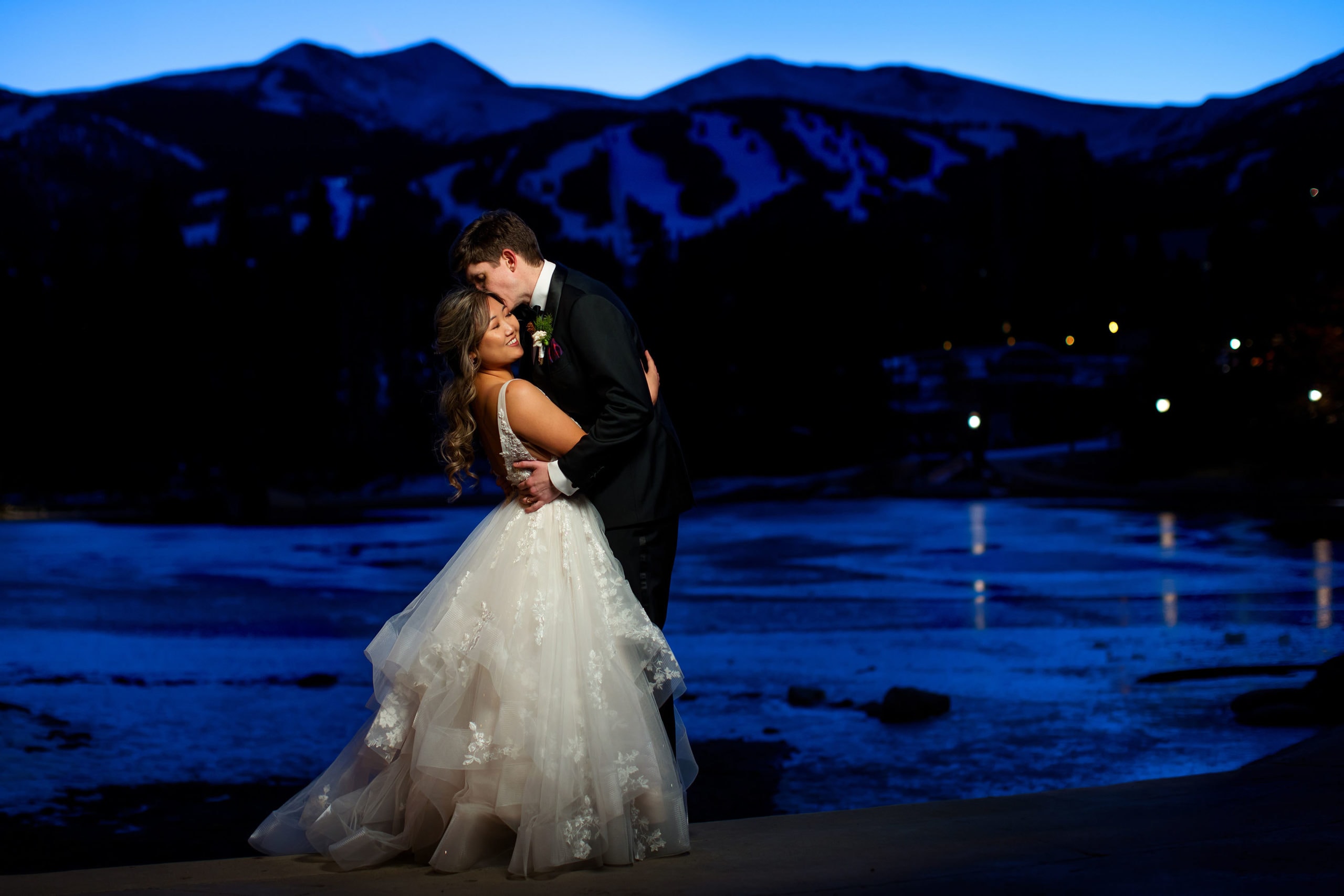 A couple poses near Main Street Station in Breckenridge during twilight on their winter wedding day