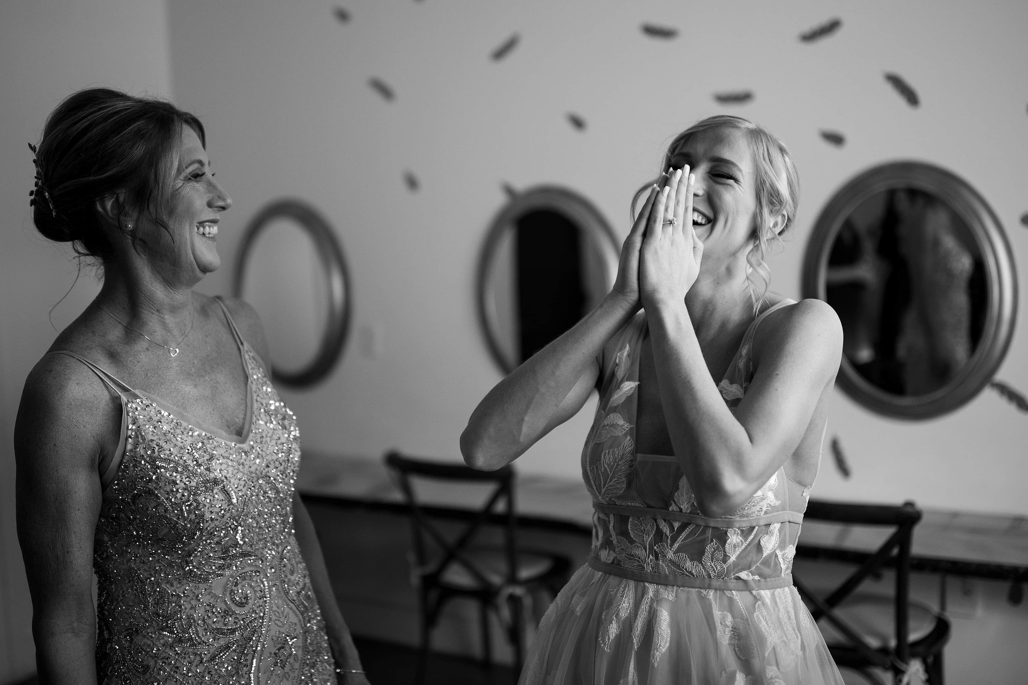 The bride shares a laugh with her mother while getting ready at Woodlands