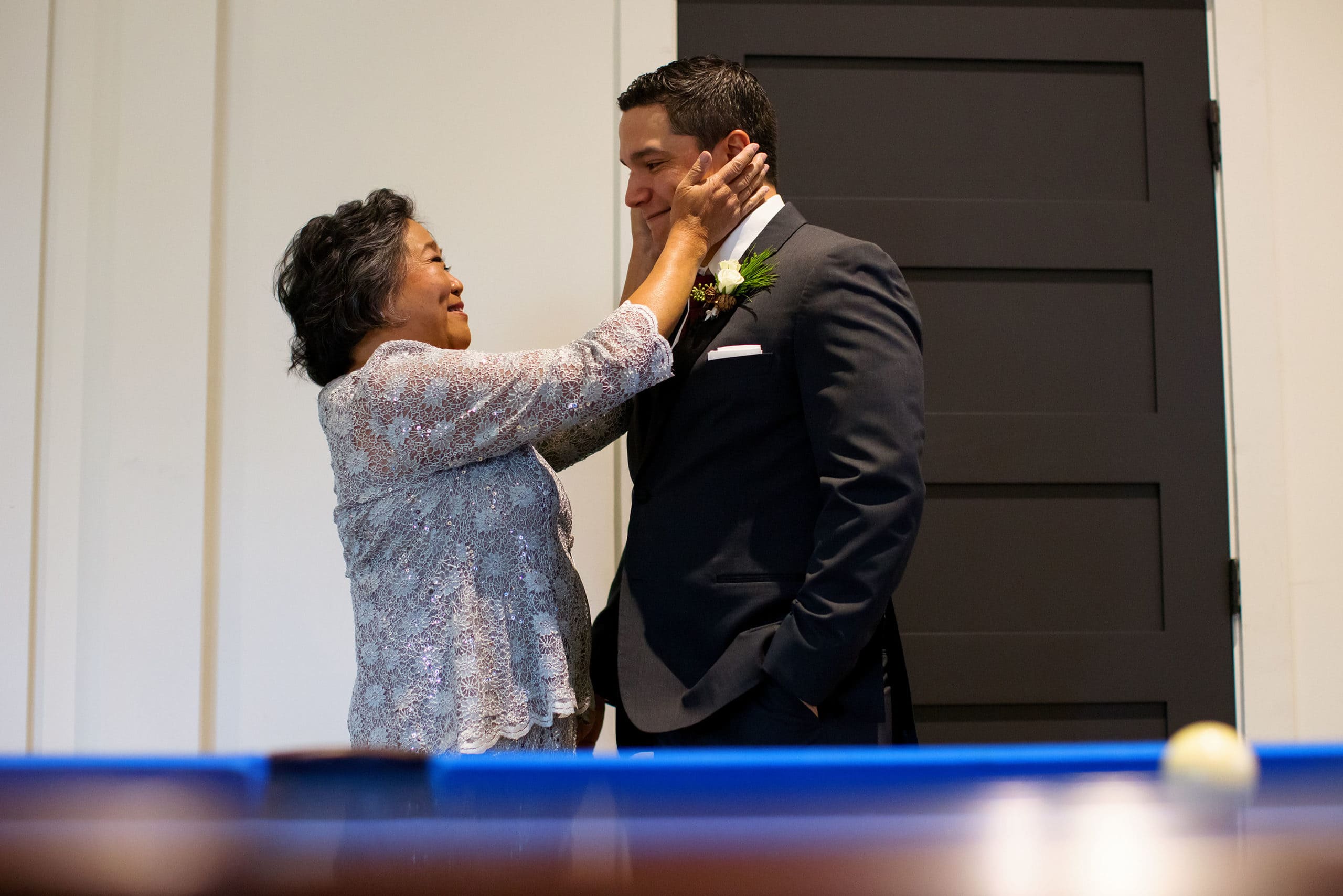 The mother of the groom embraces her son