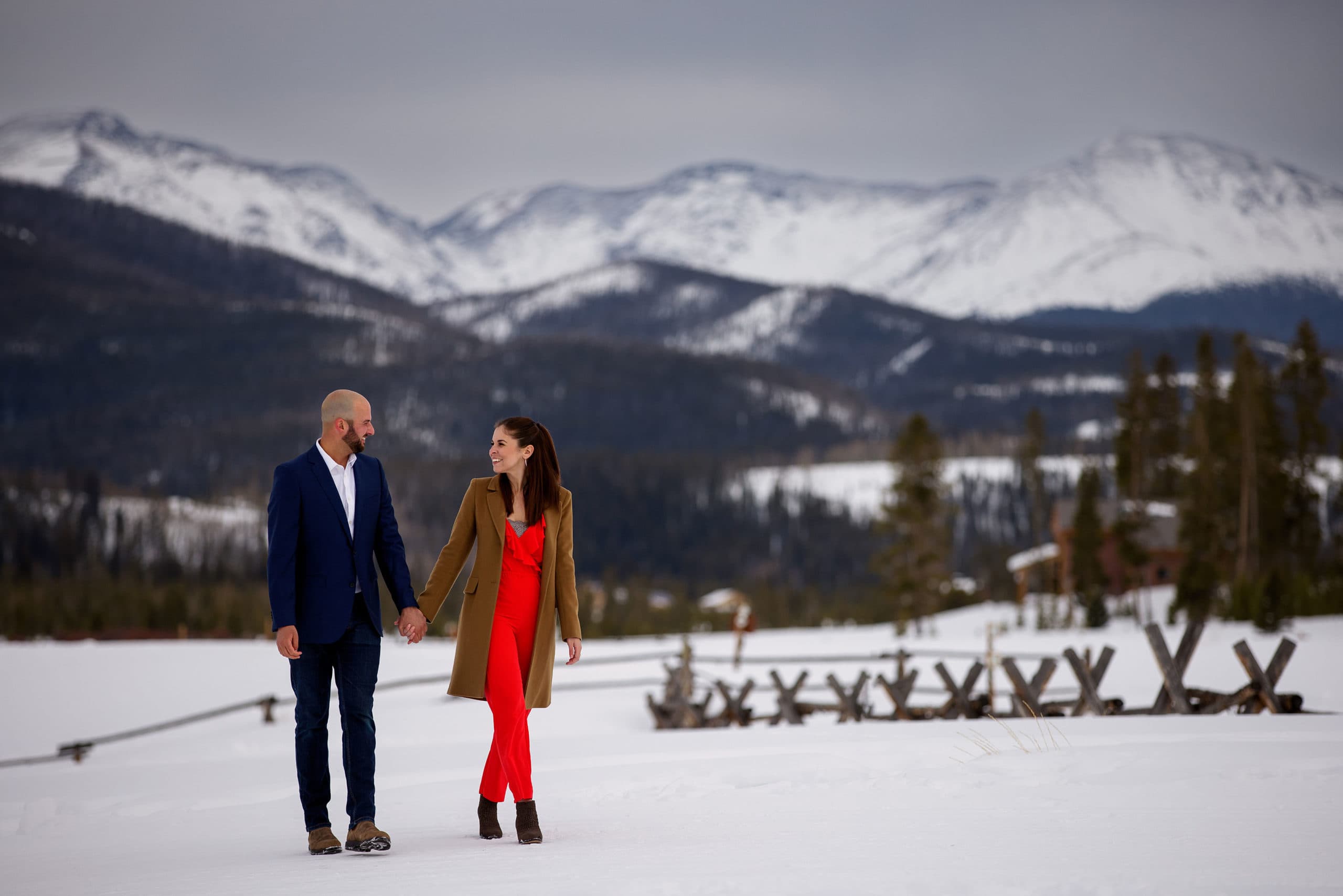 Michael and Sarah walk in the snow after getting engaged at Devil’s Thumb Ranch