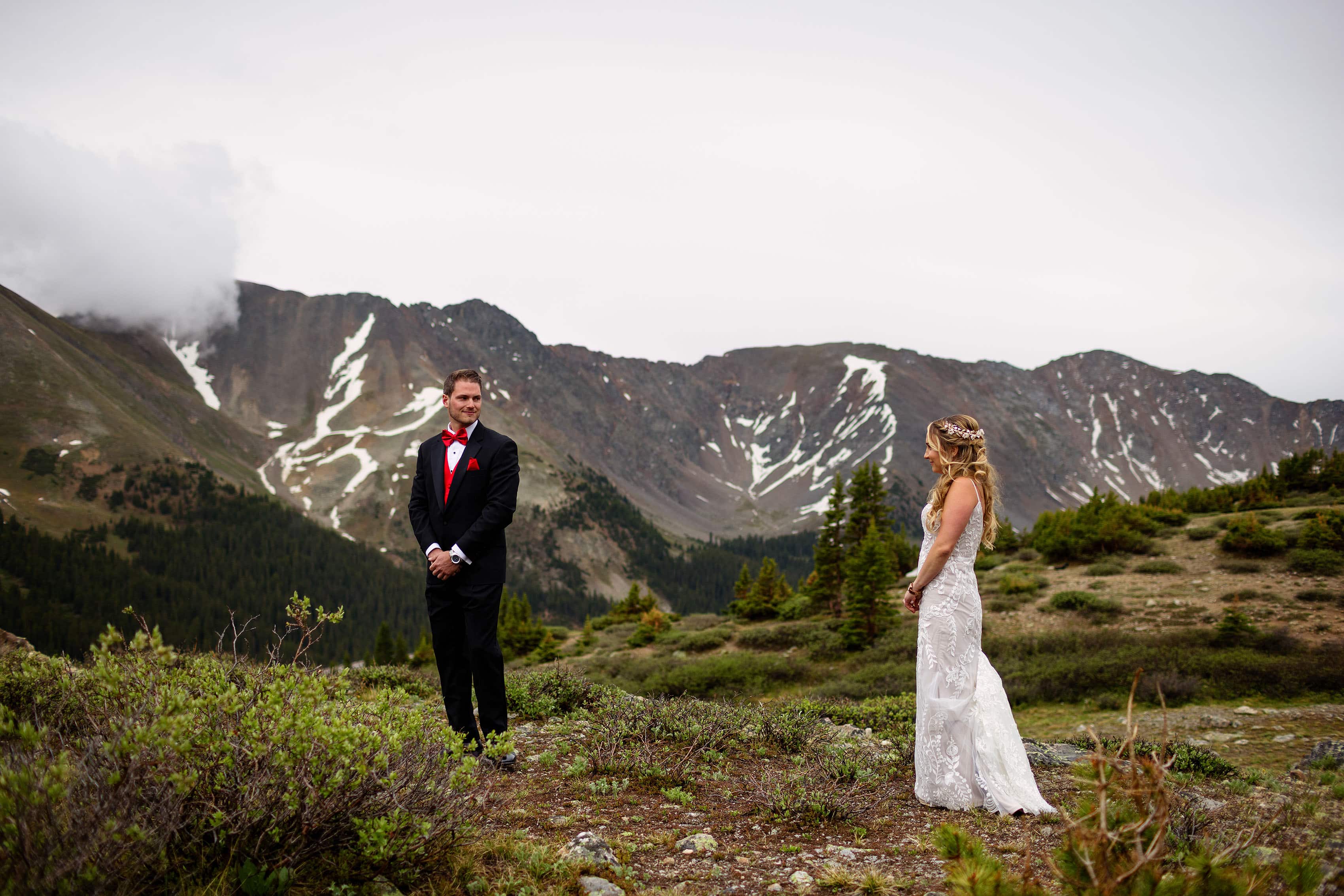 A groom and bride see each other during their first look on Loveland Pass