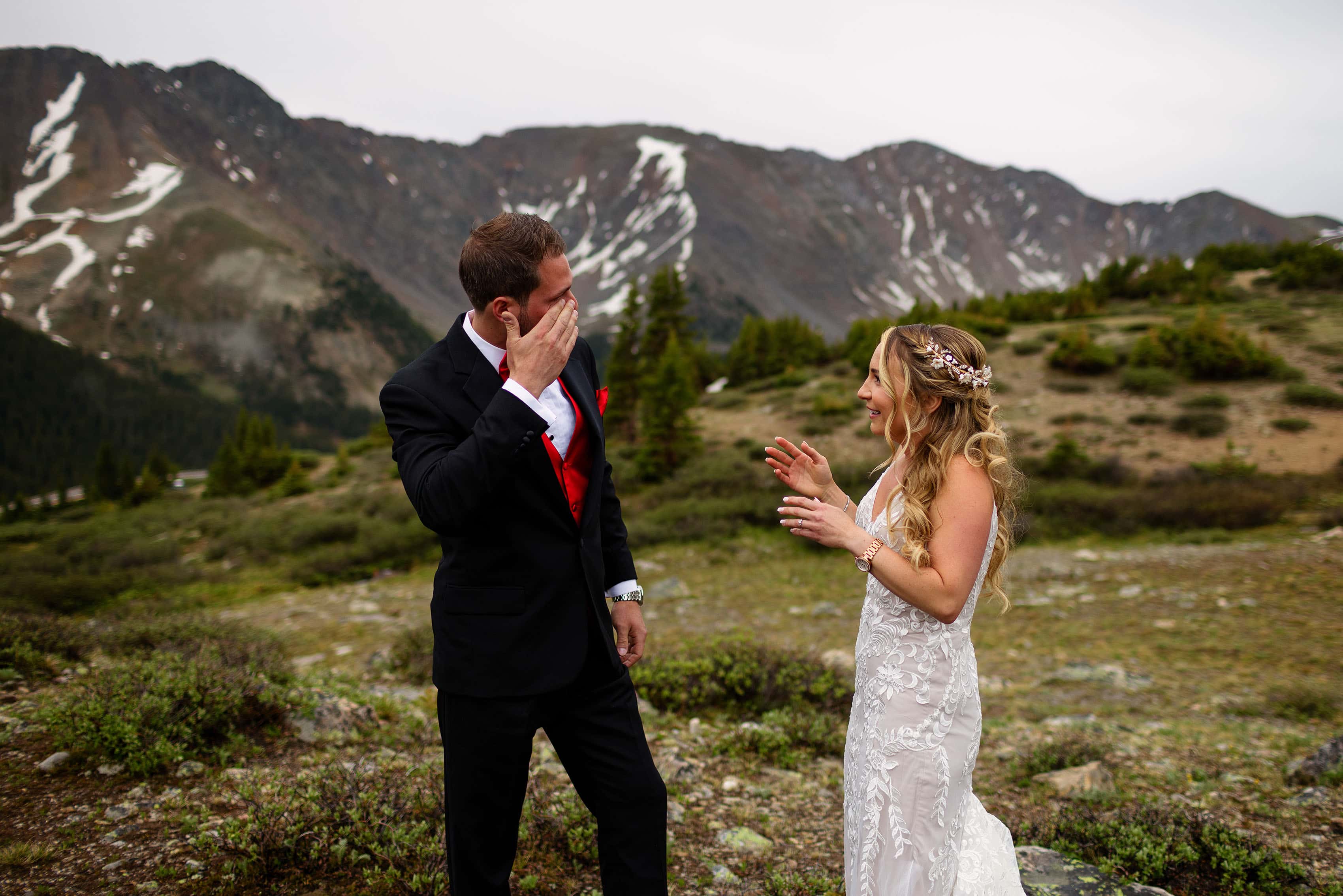The groom wipes a tear away during first look at Loveland Pass