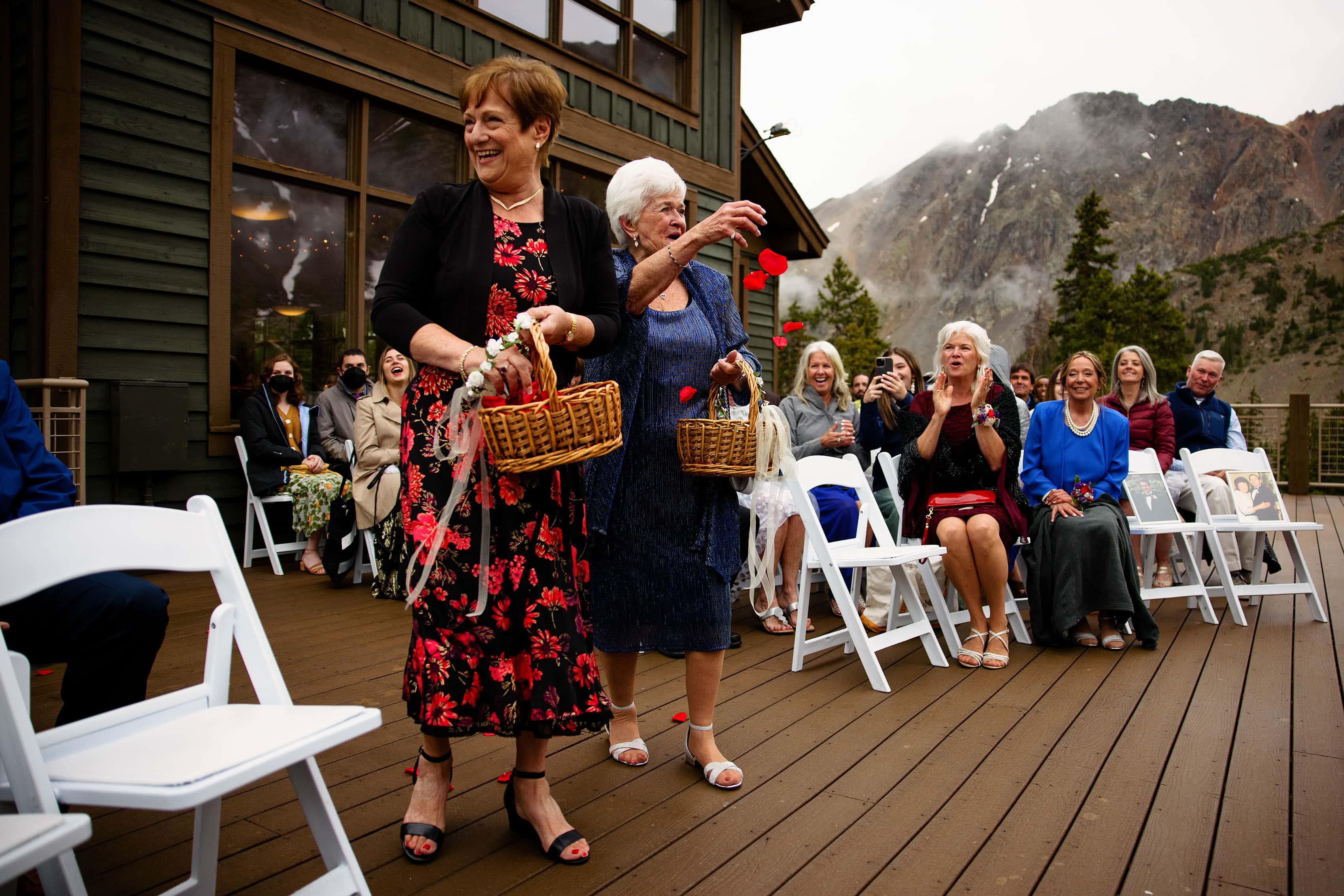 Grandmothers toss rose petals during a wedding ceremony at Arapahoe Basin