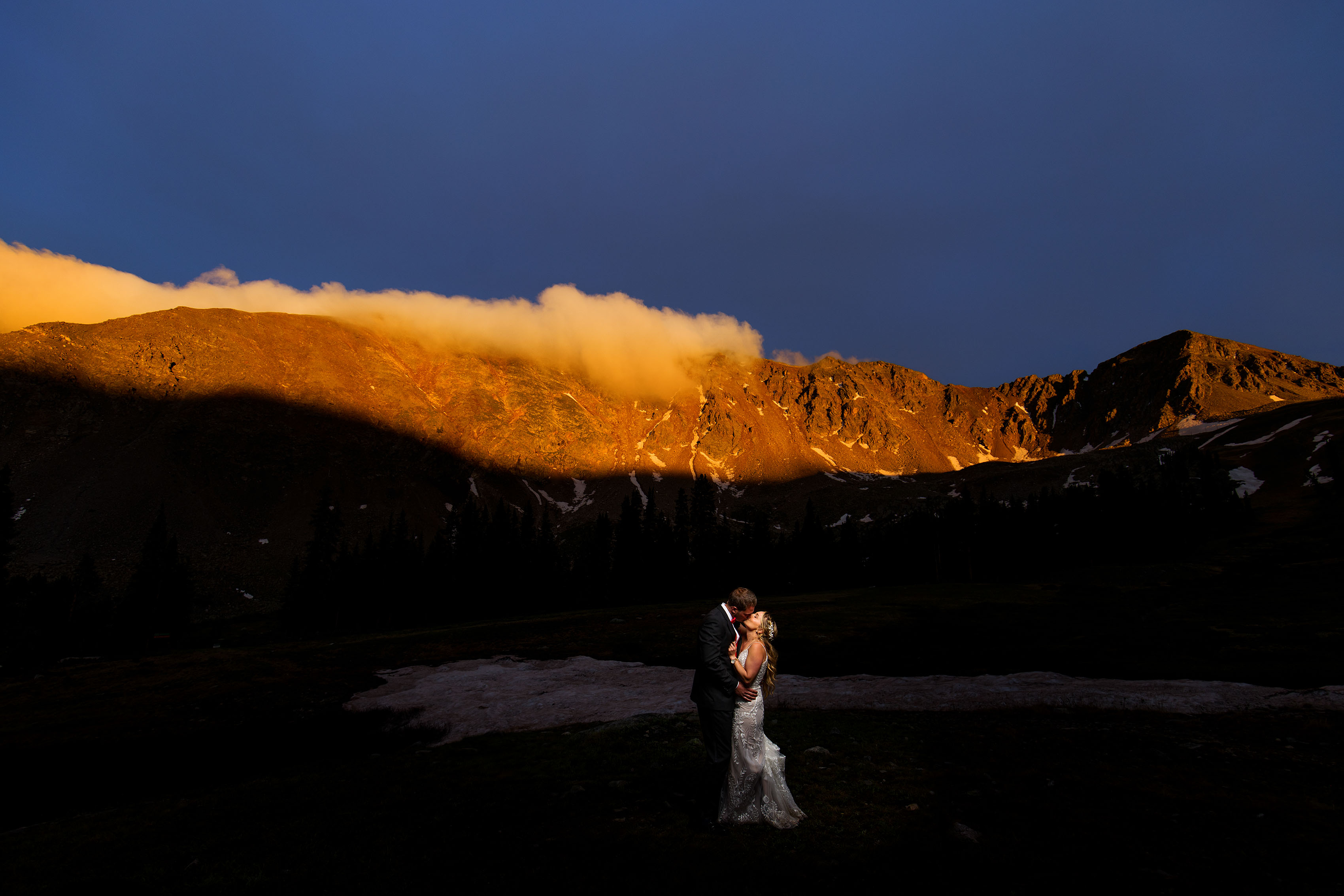 The newlyweds shares a kiss as the East wall at Arapahoe Basin is illuminated with alpenglow