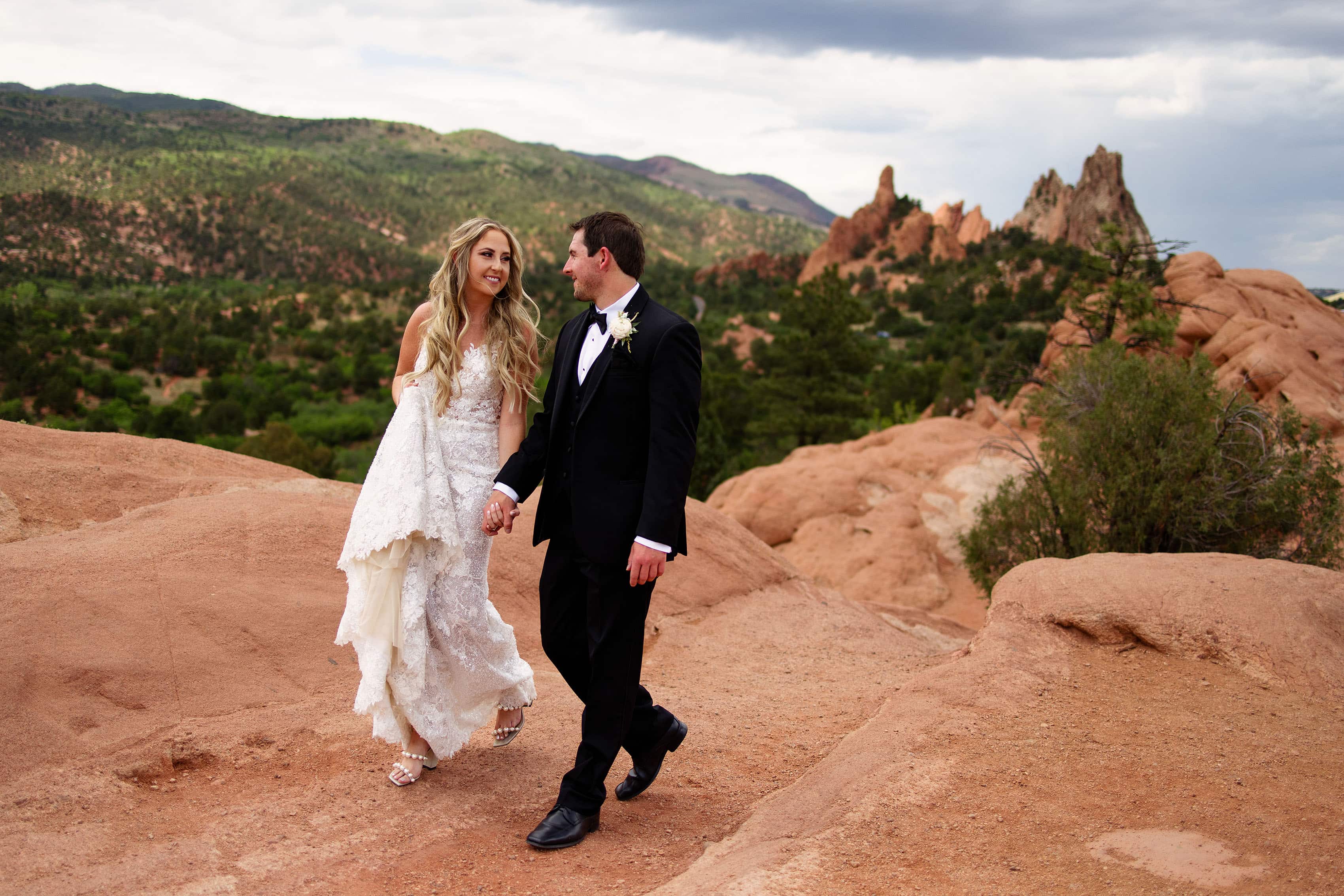 The bride and groom walk together in Garden of the Gods Park