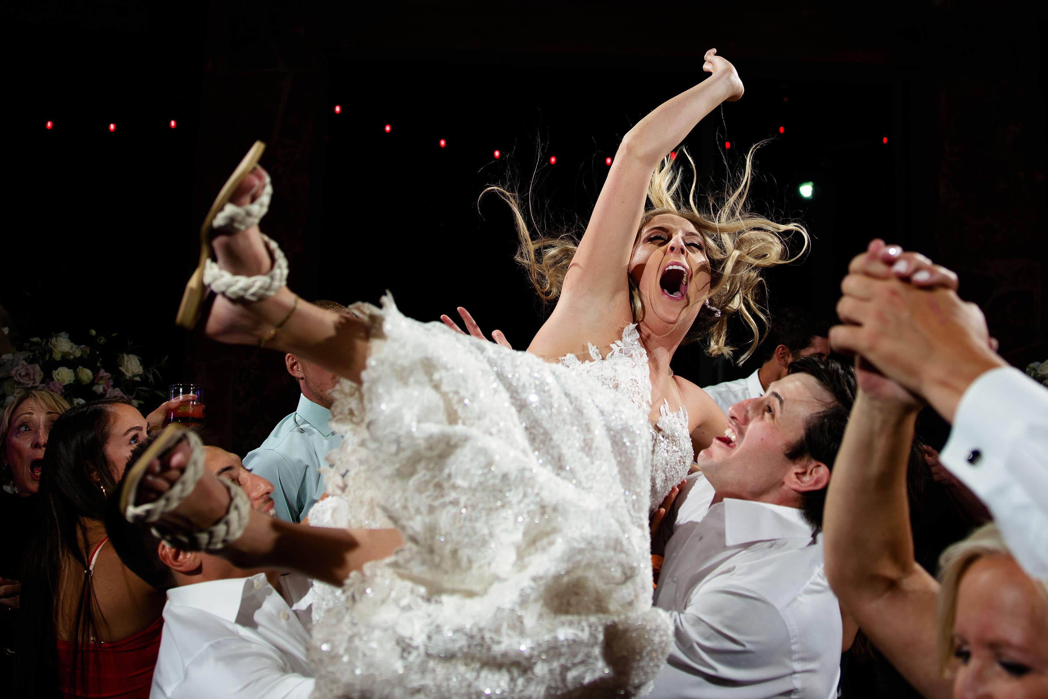 The bride is thrown into the air by friends during the reception