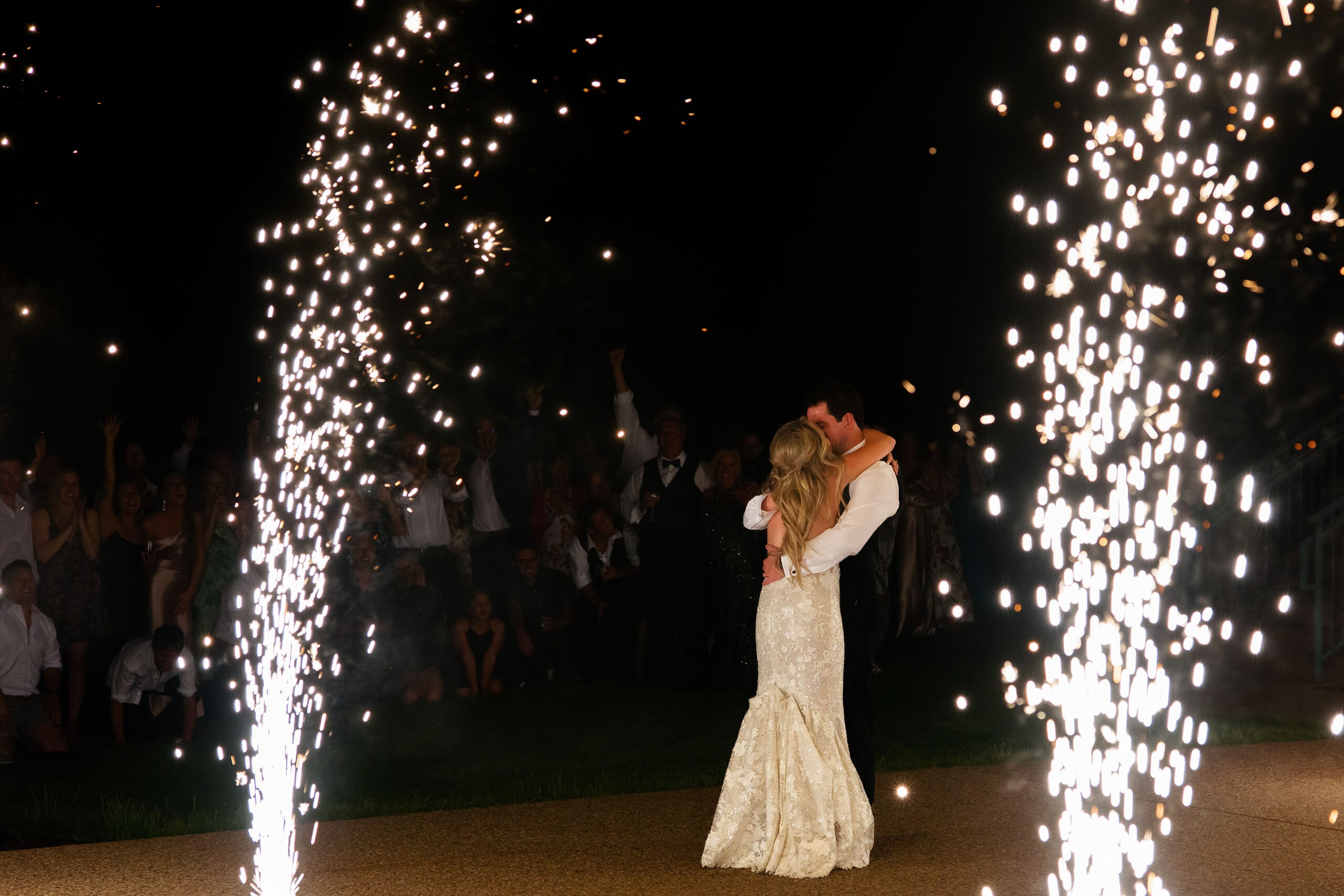 The bride and groom kiss as fireworks go off during their grand exit after their wedding at Garden of the Gods resort
