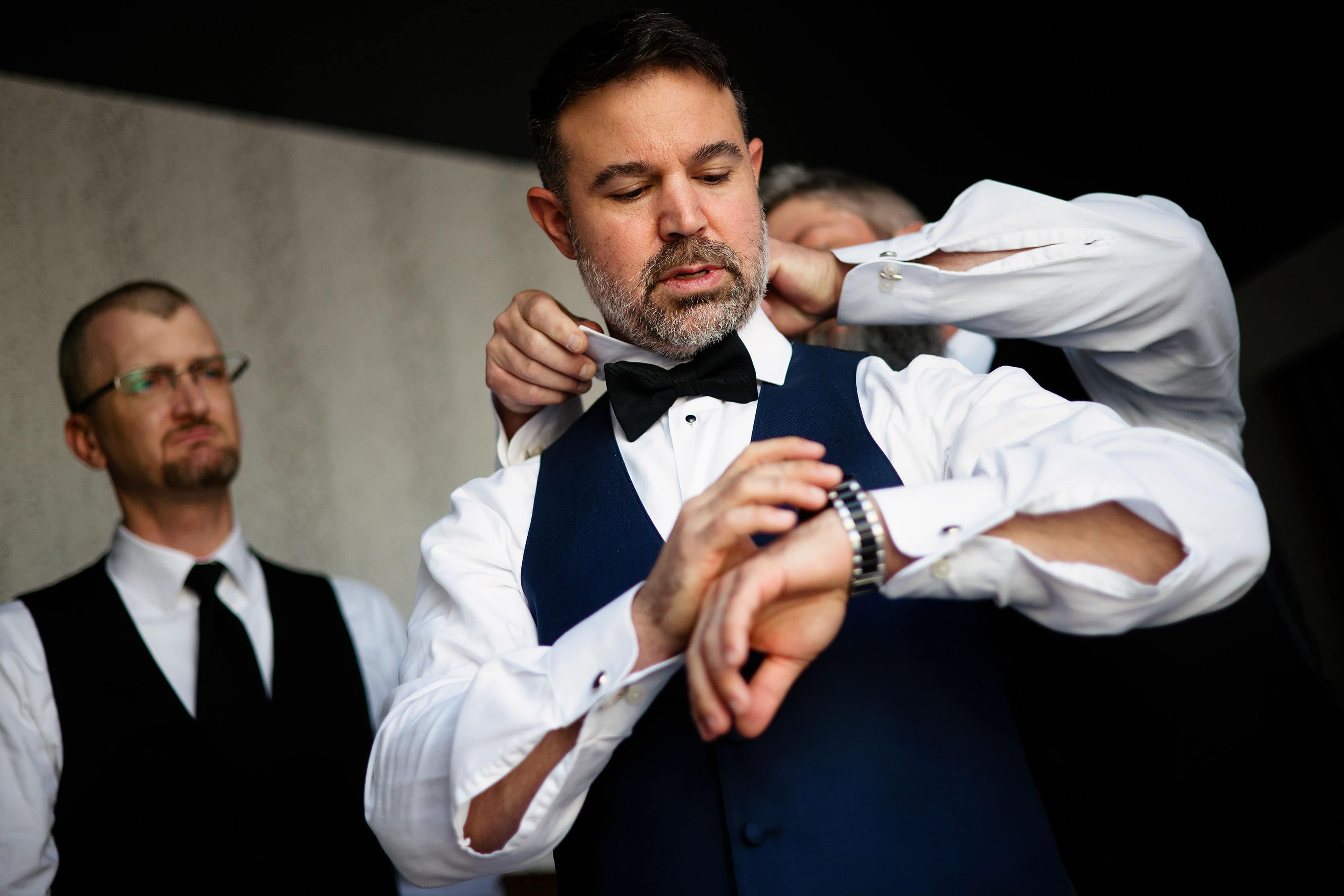 The groom adjusts his watch