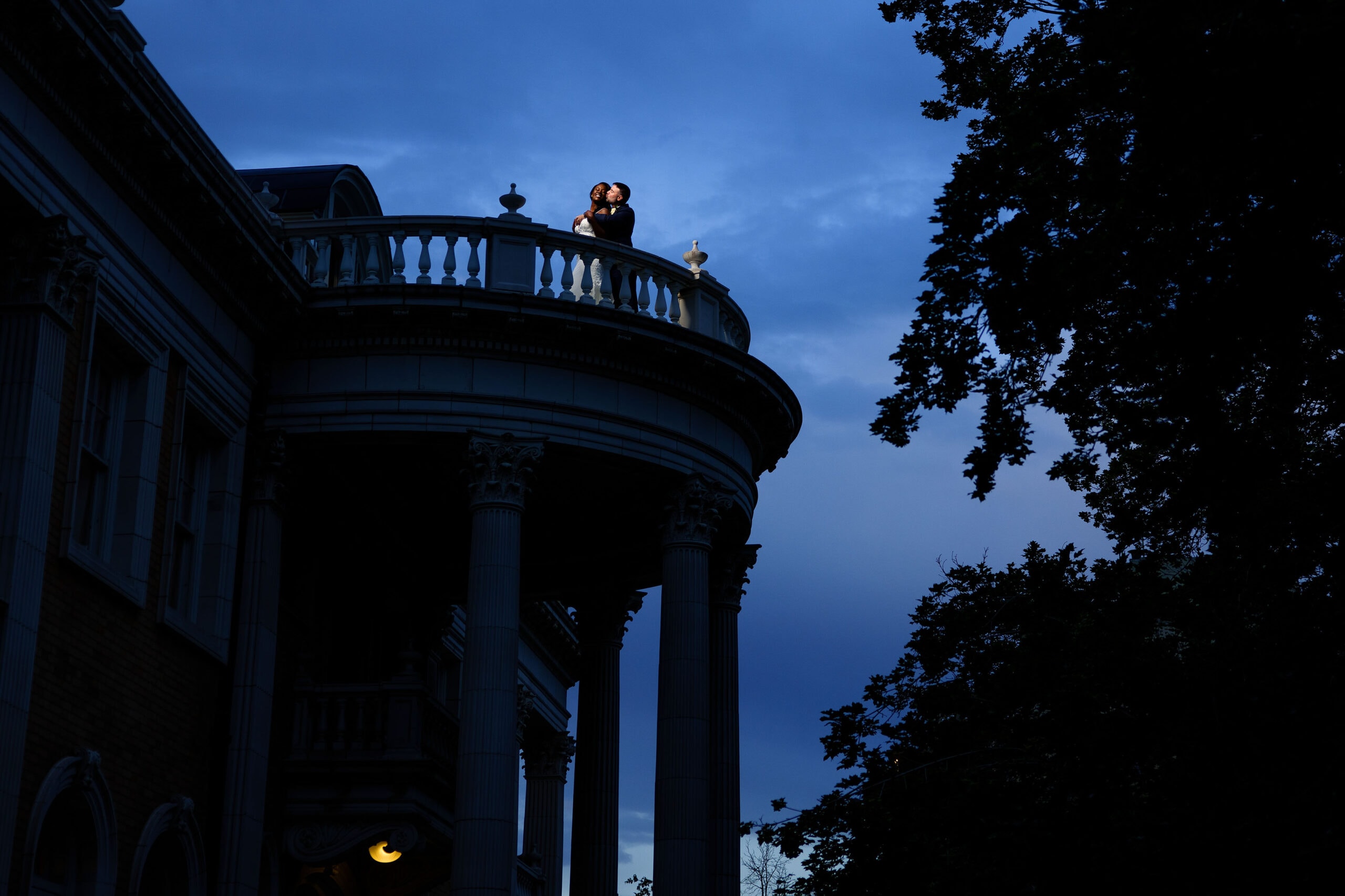 Shad kisses Aisha atop the balcony during twilight at Grant Humphrey’s Mansion