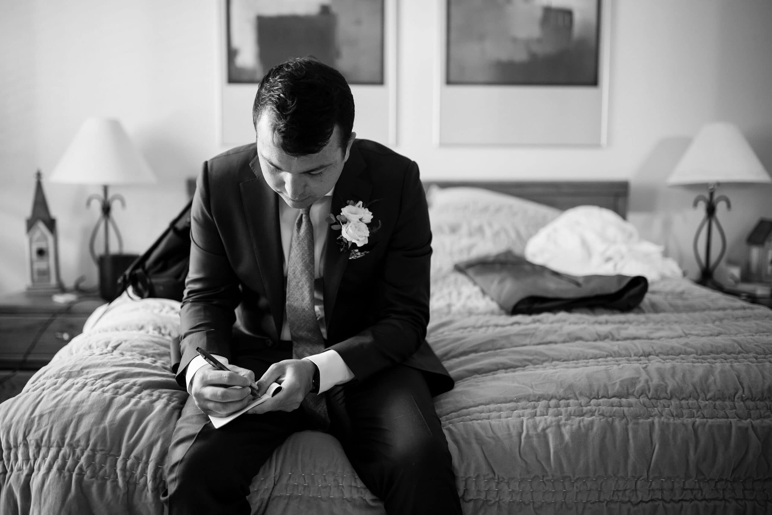The groom writes his vows on his bed
