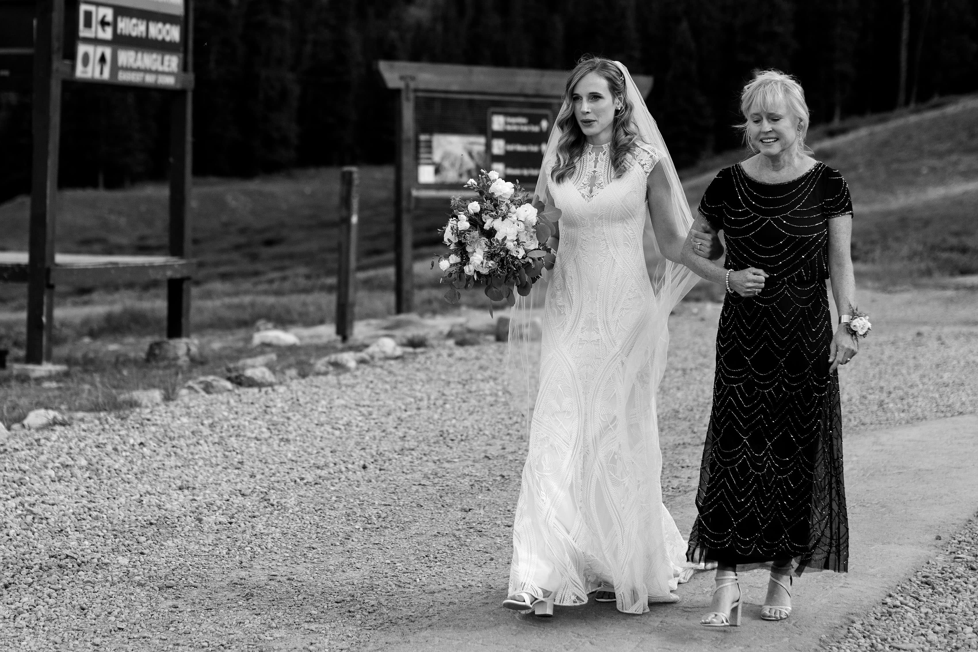 The bride exhales while walking down a path to the ceremony