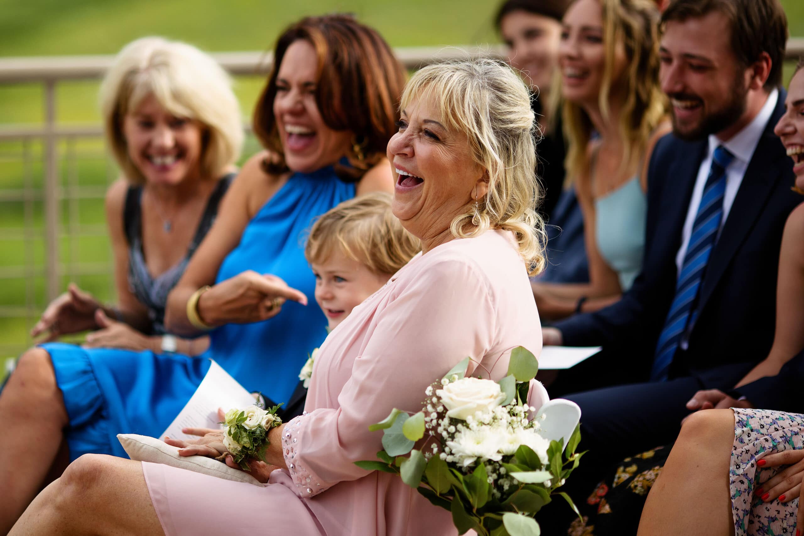 Mother of the groom and guests laugh during the ceremony