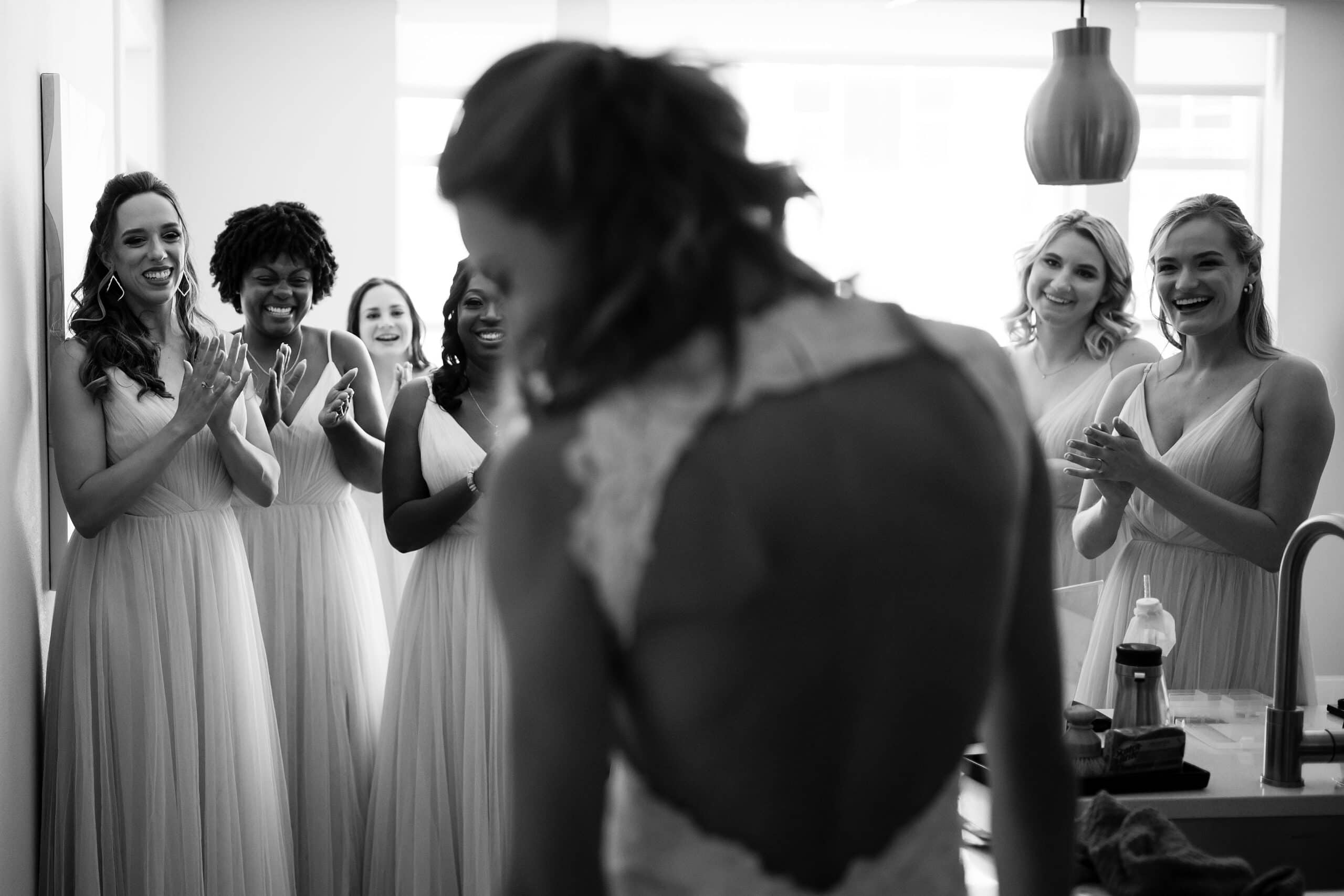 Bridesmaids react to seeing the bride in her gown