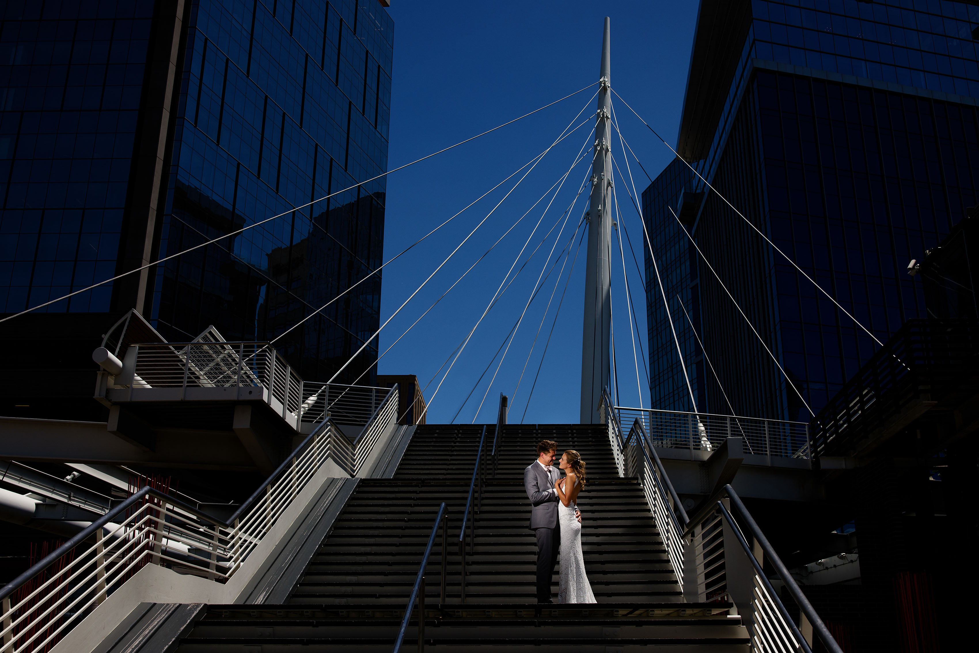 A couple poses on the Denver millennium bridge during their wedding day