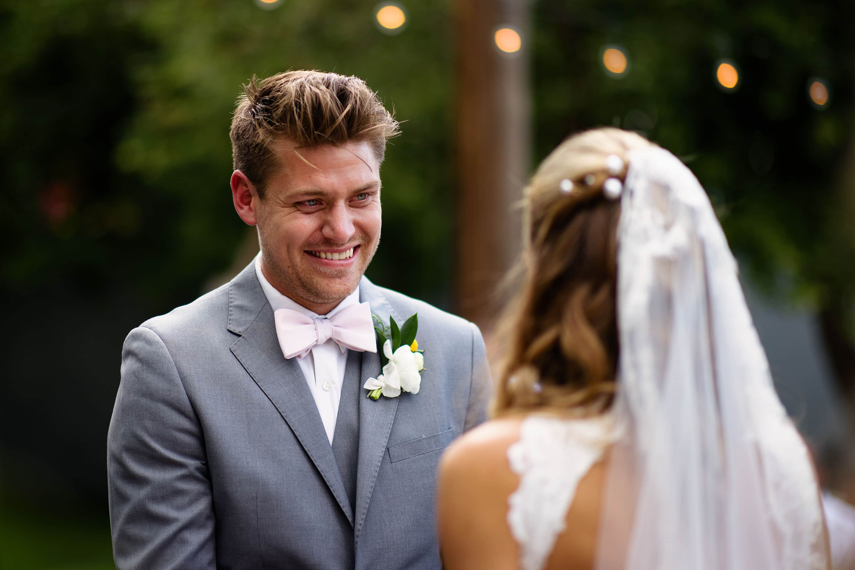 The groom smiles at the bride during the ceremony