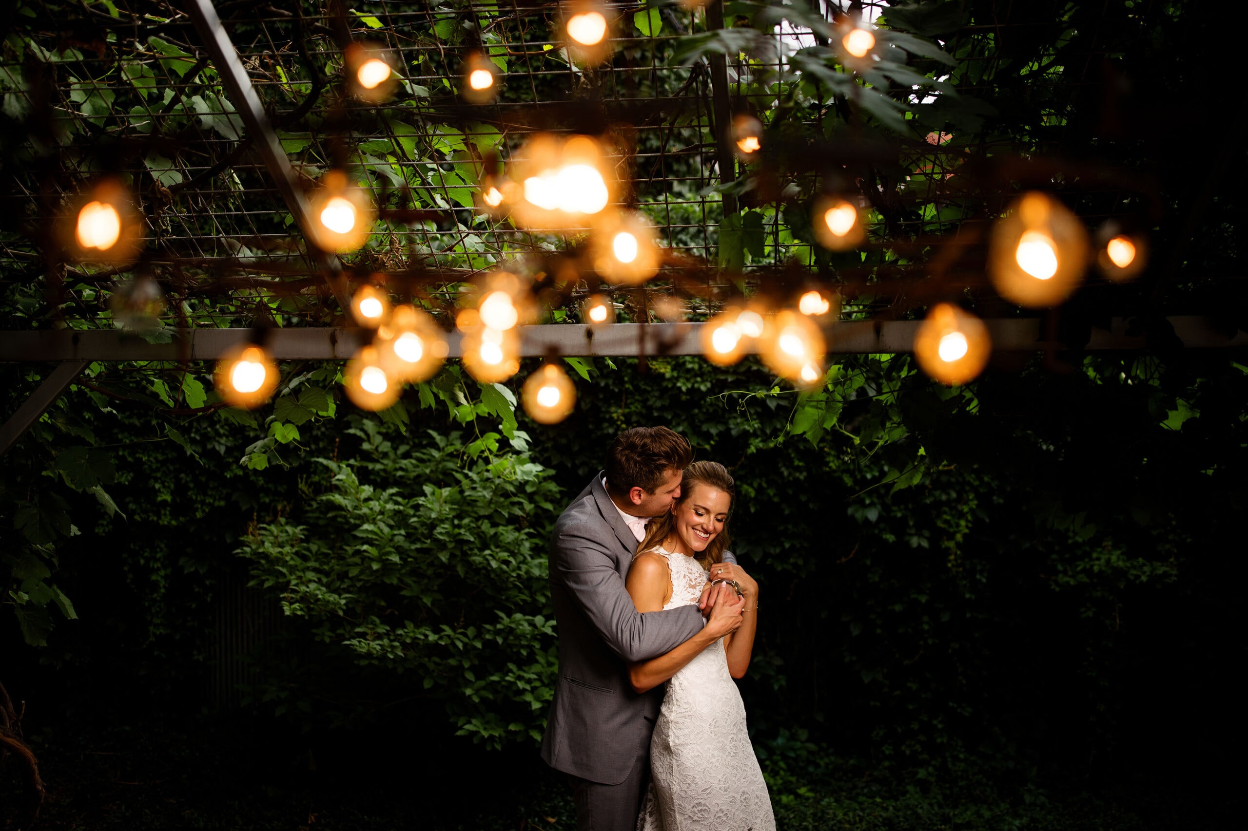 The bride and groom embrace under the market lights at Blanc on their wedding day