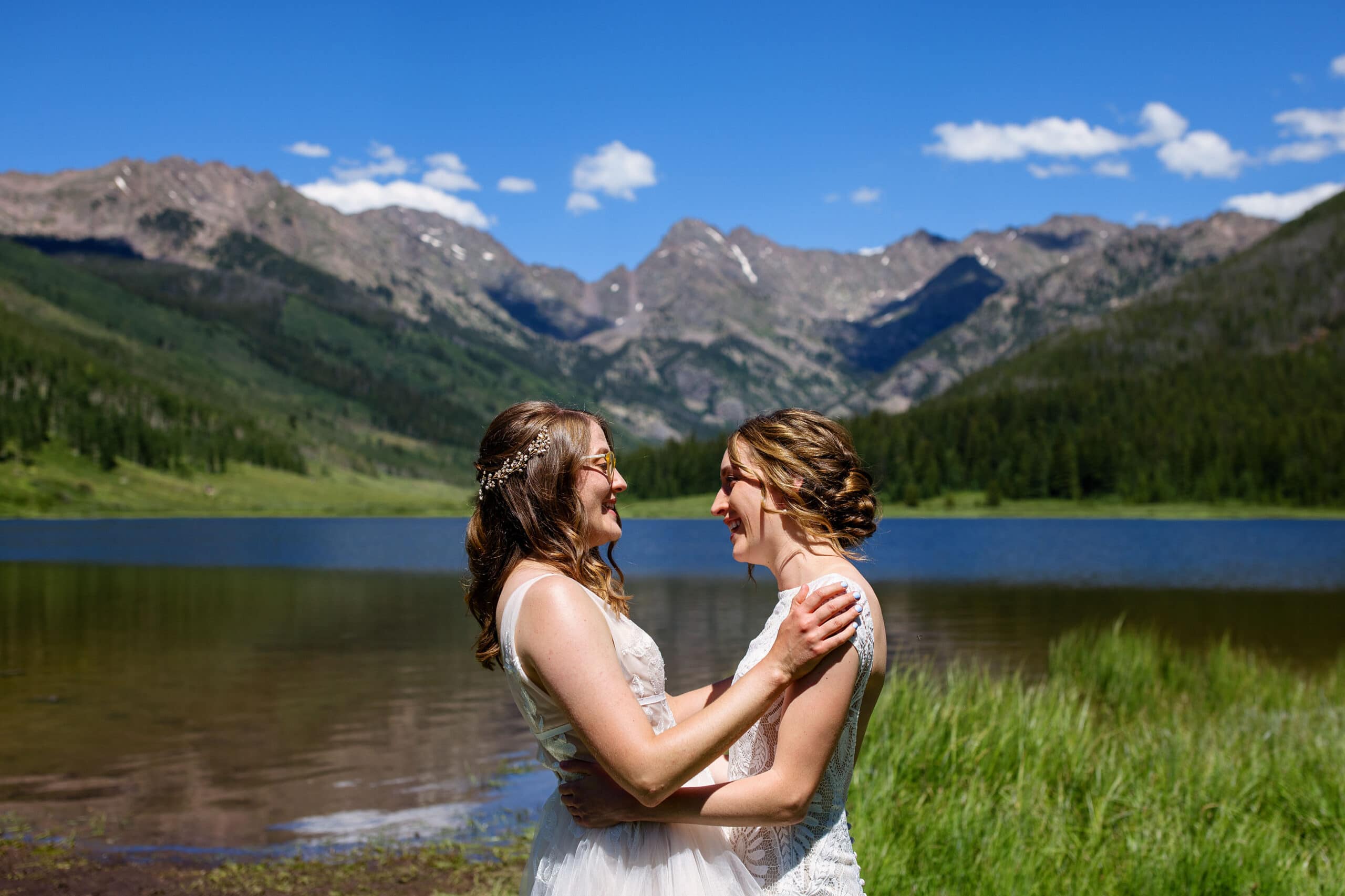 The brides share a moment together during their first look at Piney Lake