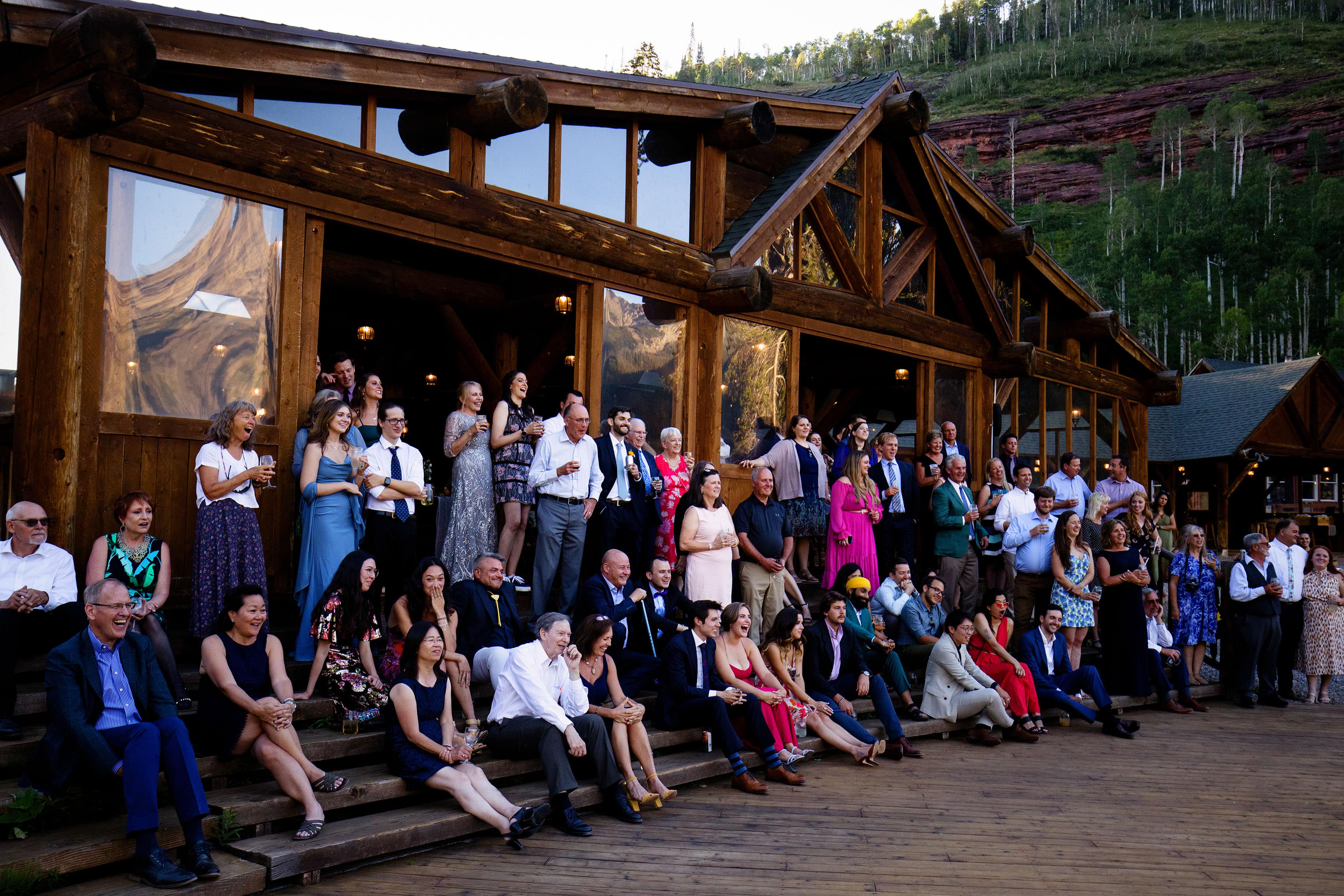 Wedding guests listen to a toast from the steps of Piney River Ranch