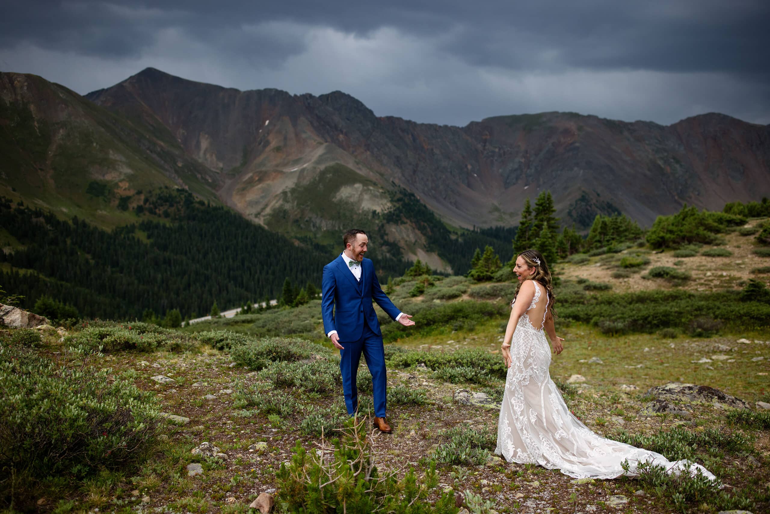 The bride and groom react during their first look at Pass Lake on Loveland Pass