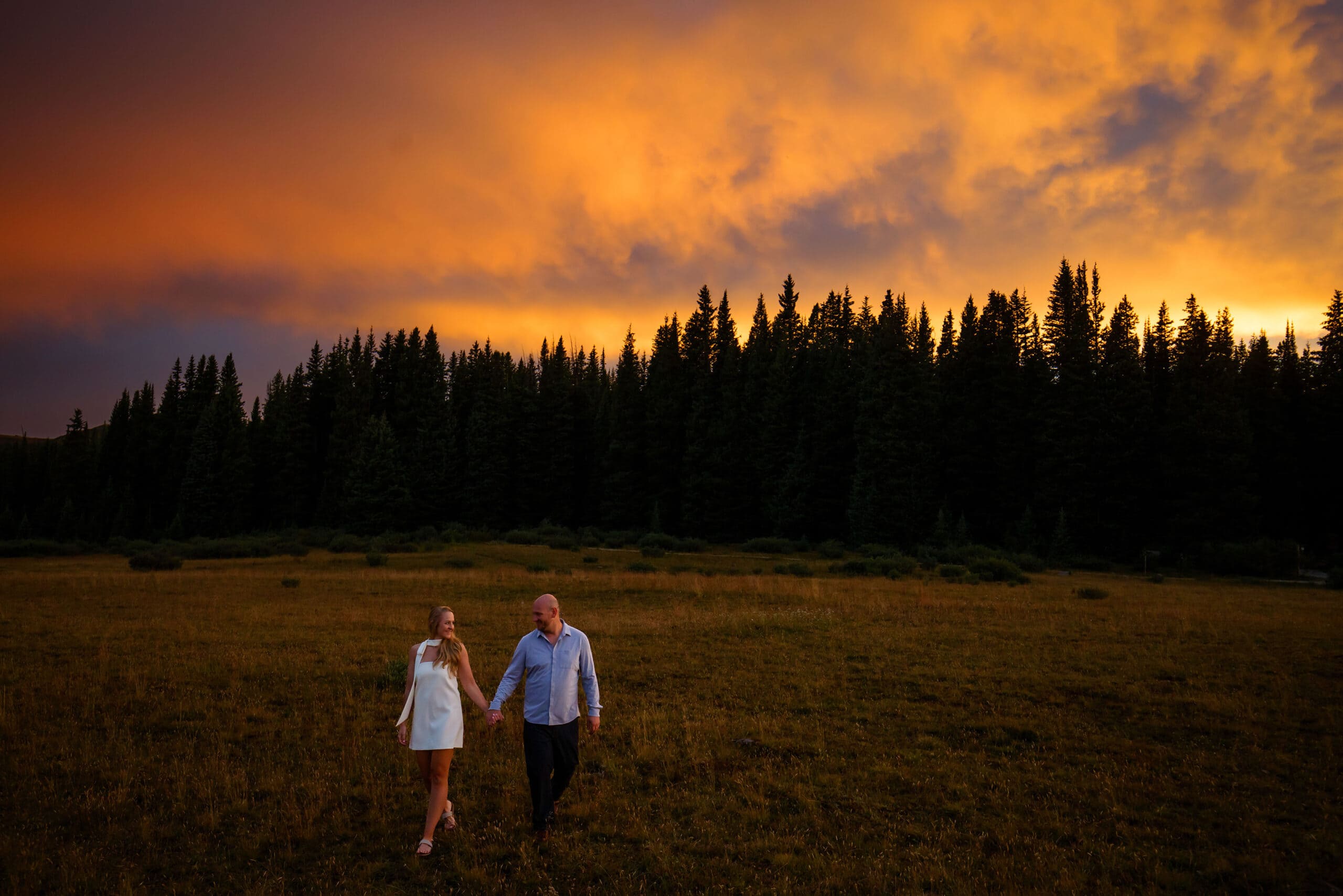 A couple walks together at sunset on Shrine Pass