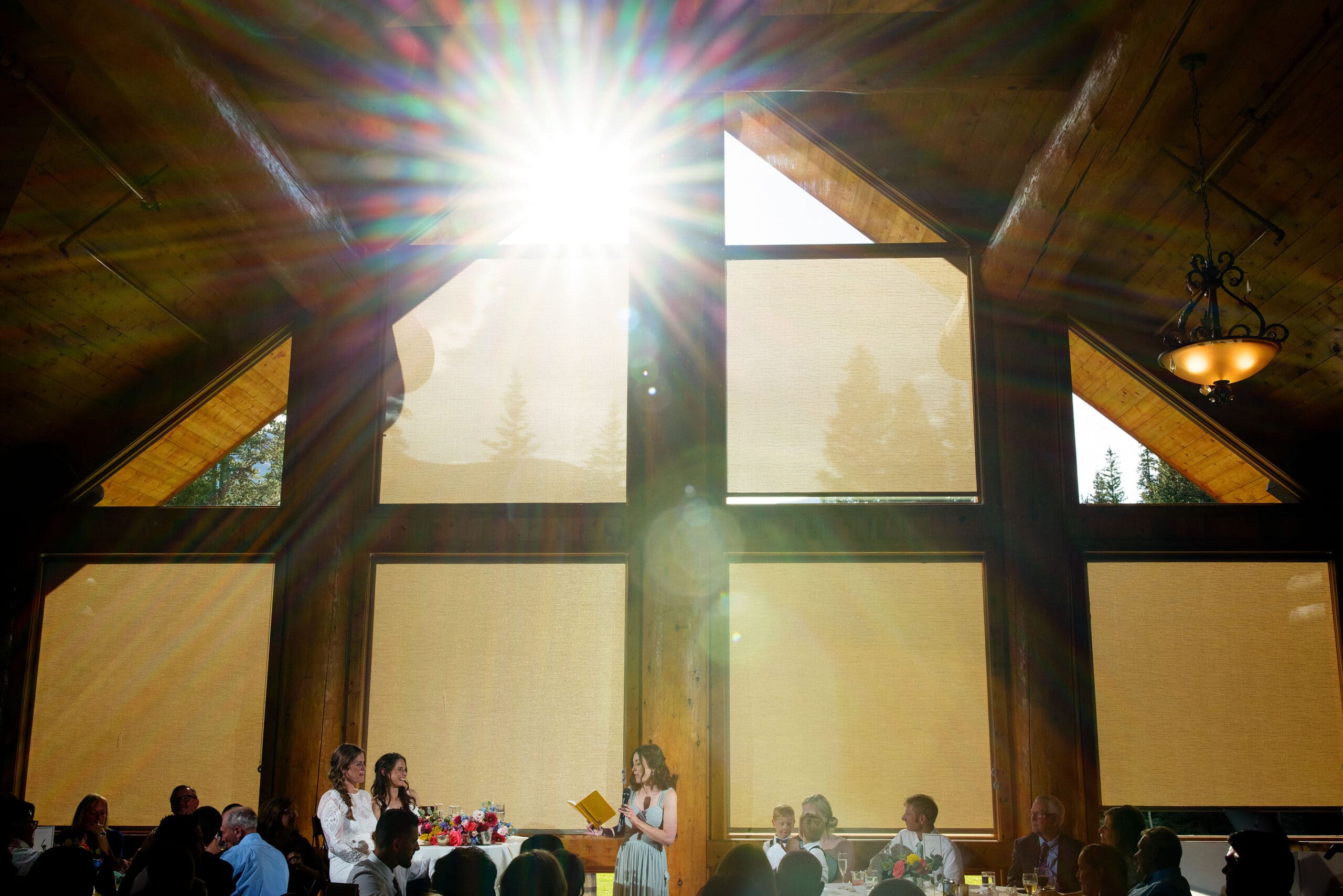 The suns shines through the windows as the maid of honor gives a toast