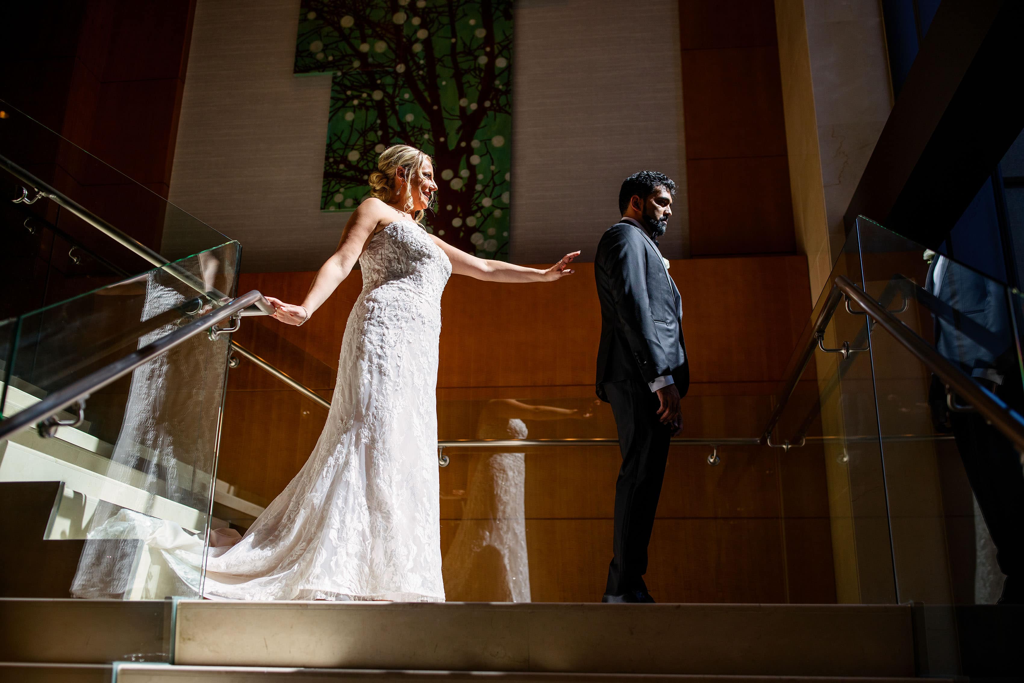 The bride reaches out for the groom during their first look at the Four Seasons Hotel Denver