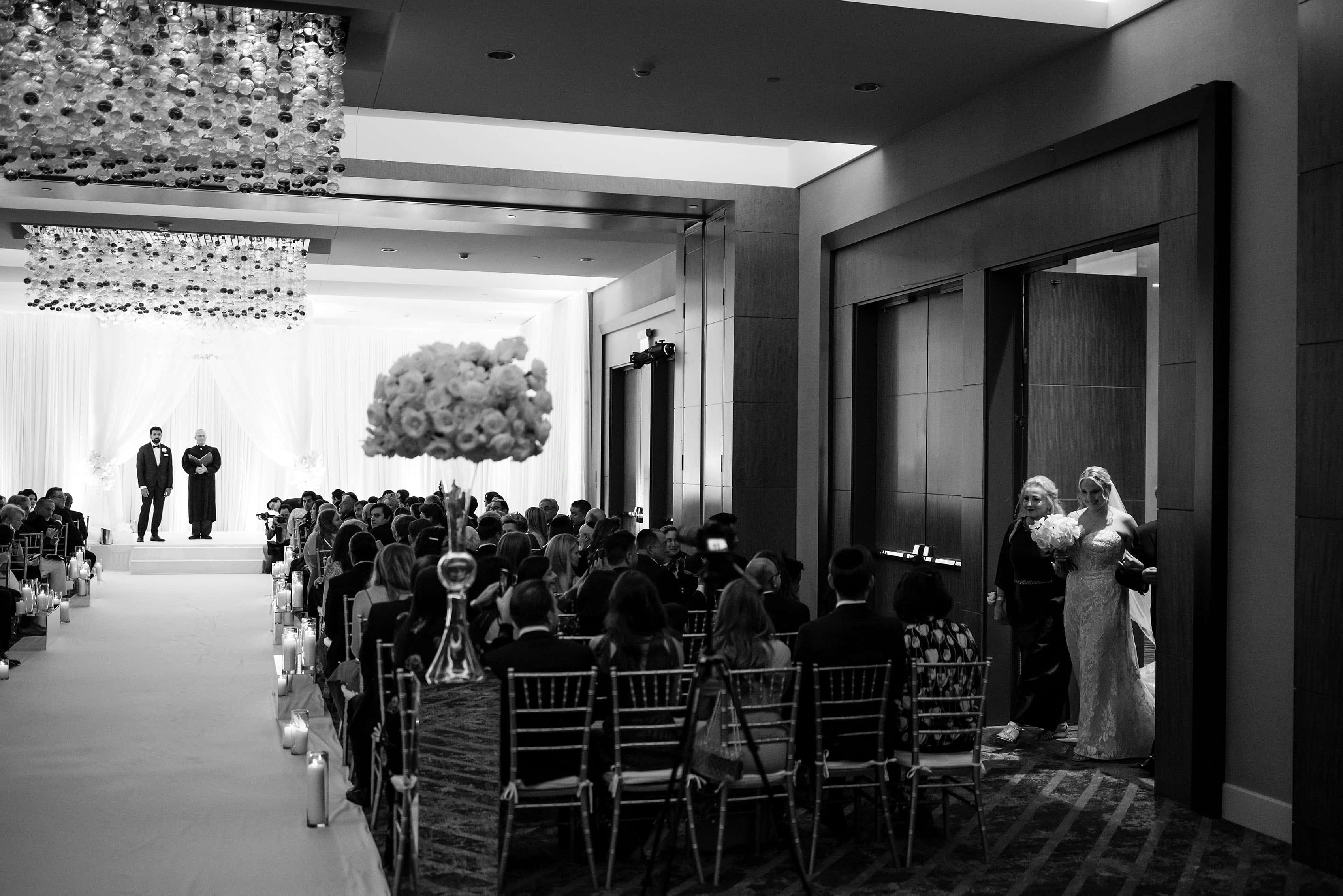 The bride enters the ballroom during the ceremony at Four Seasons Hotel Denver