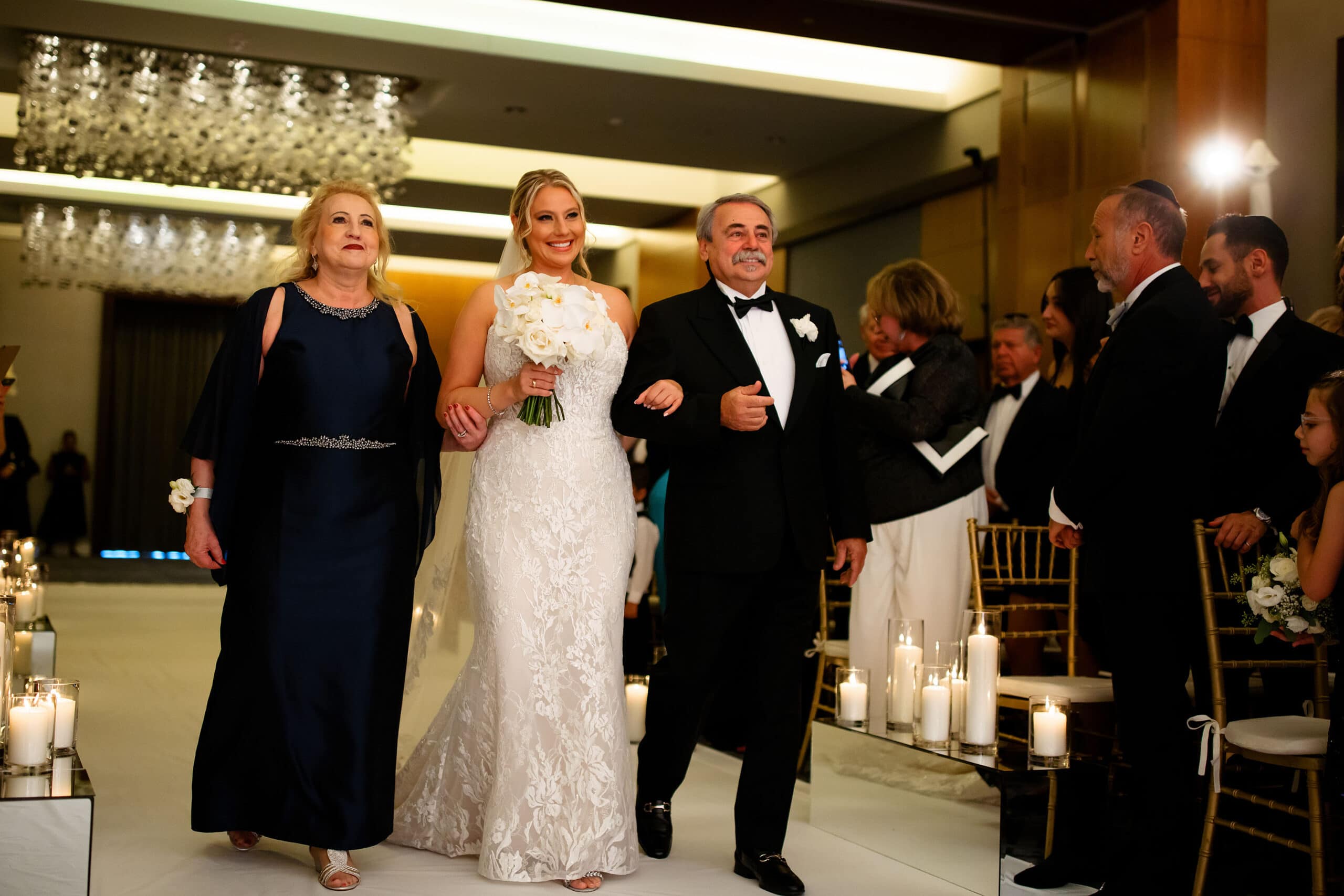 The bride walks down the aisle at Four Seasons Hotel Denver with her parents