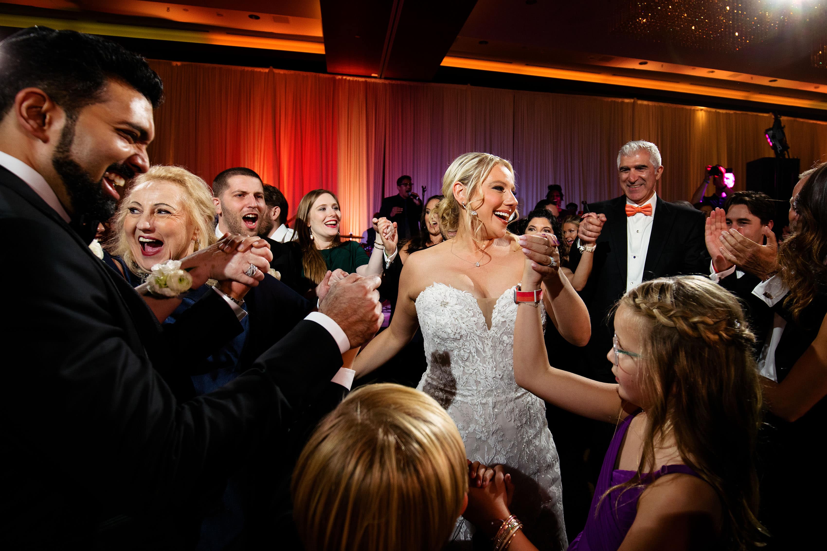 The couple dances with family members at their ballroom reception