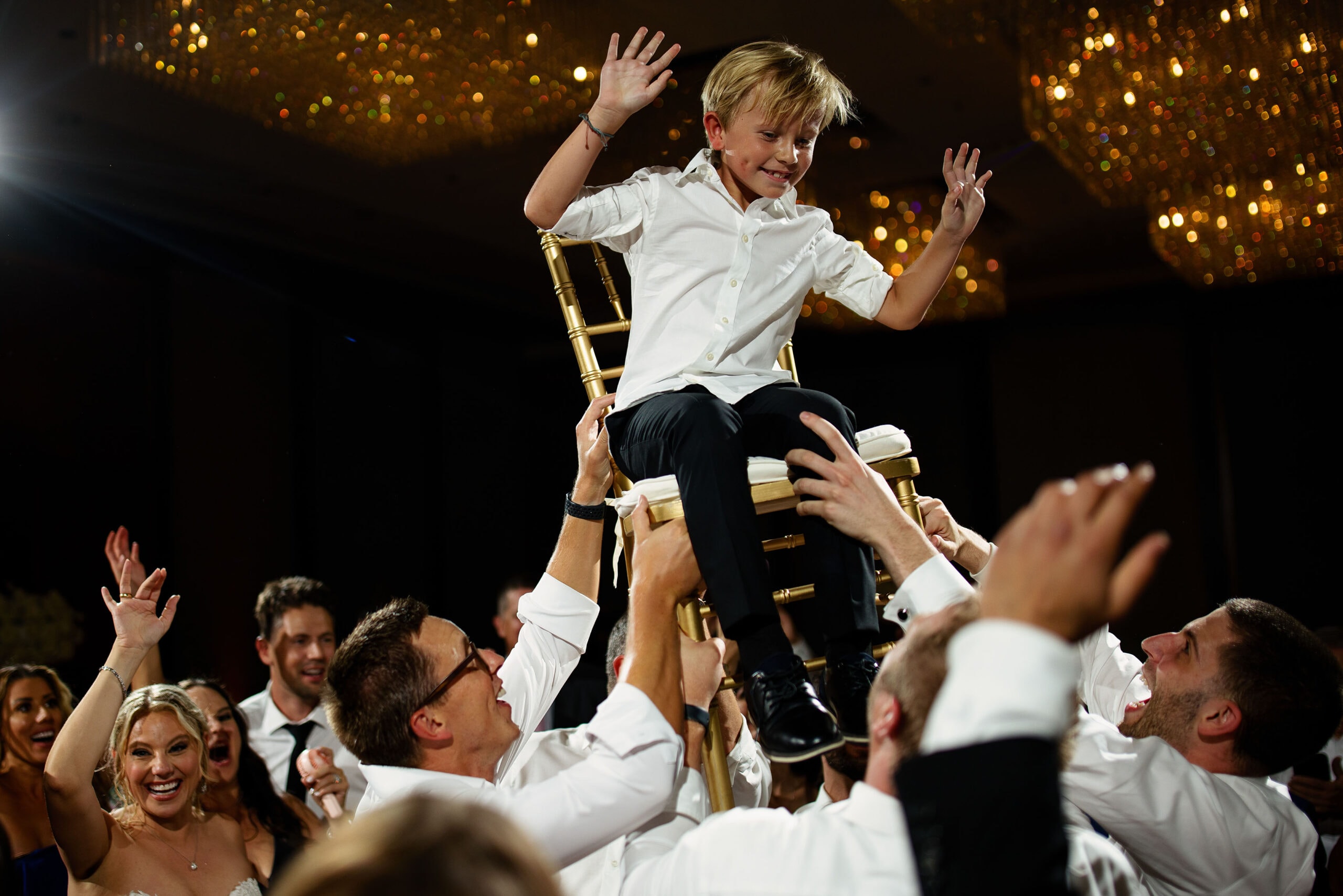 A young guest is lifted into the air during a wedding reception at Four Seasons Hotel Denver