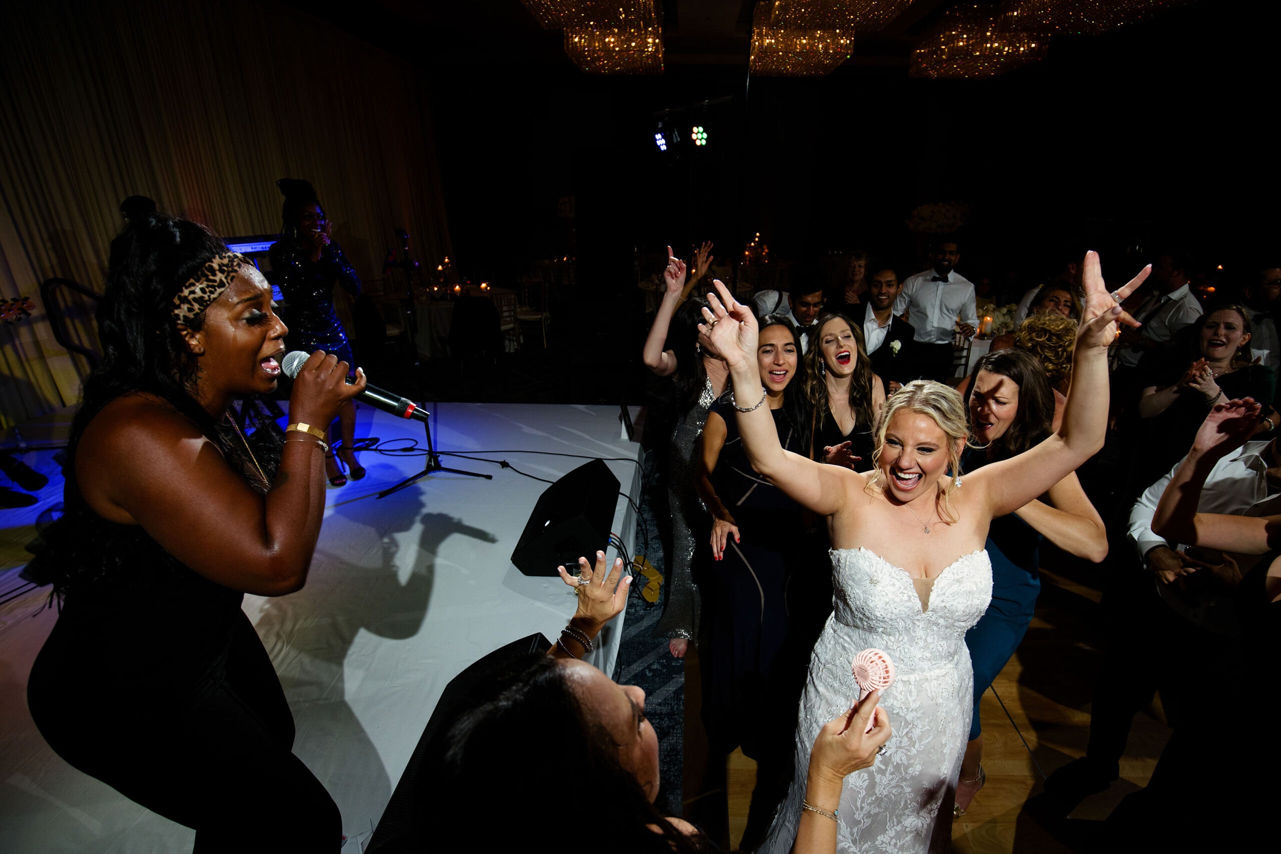 A singer from Bounce Band performs as the bride dances during her wedding reception at Four Seasons Hotel Denver