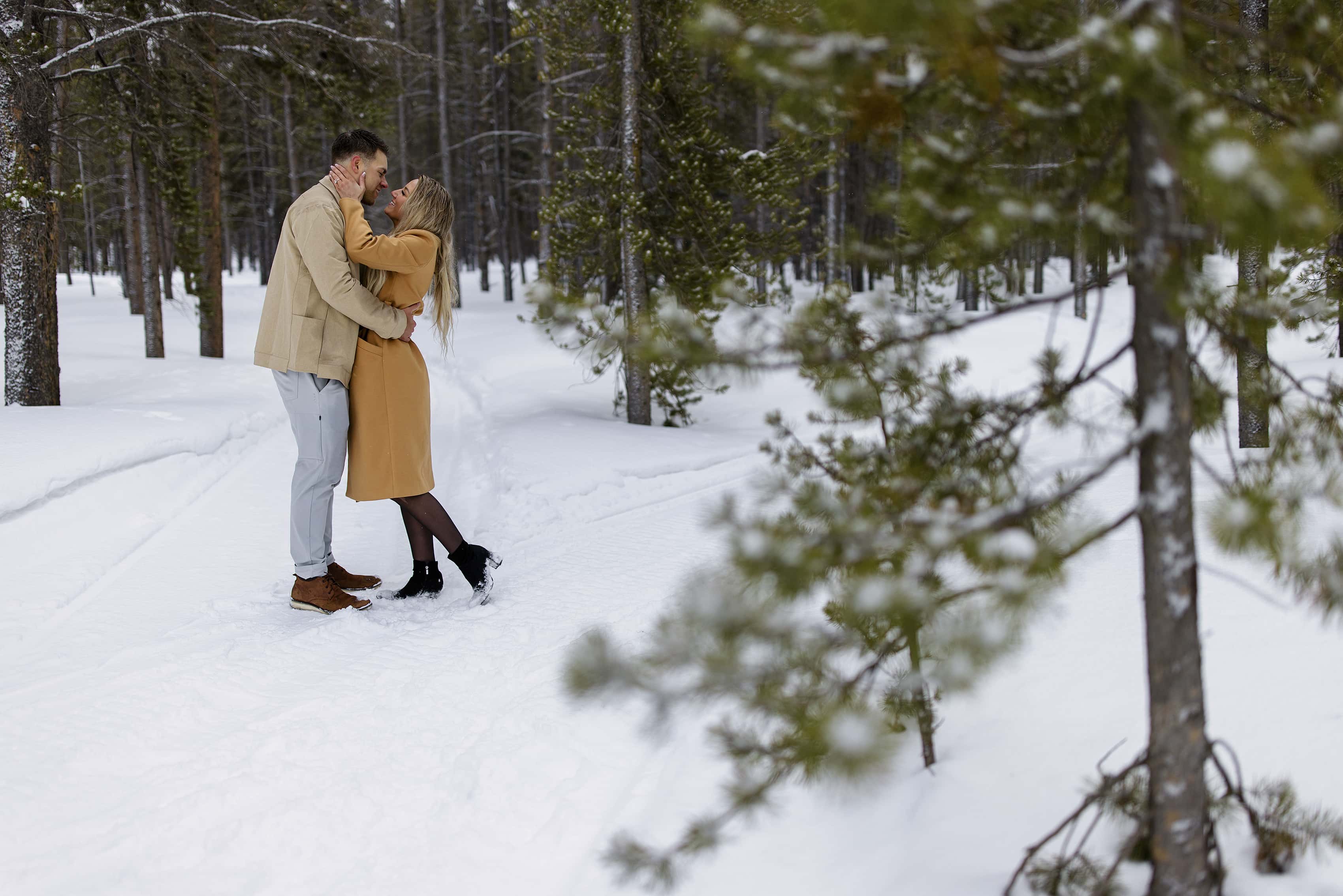 A couple embraces along a snowy trail in Breckenridge