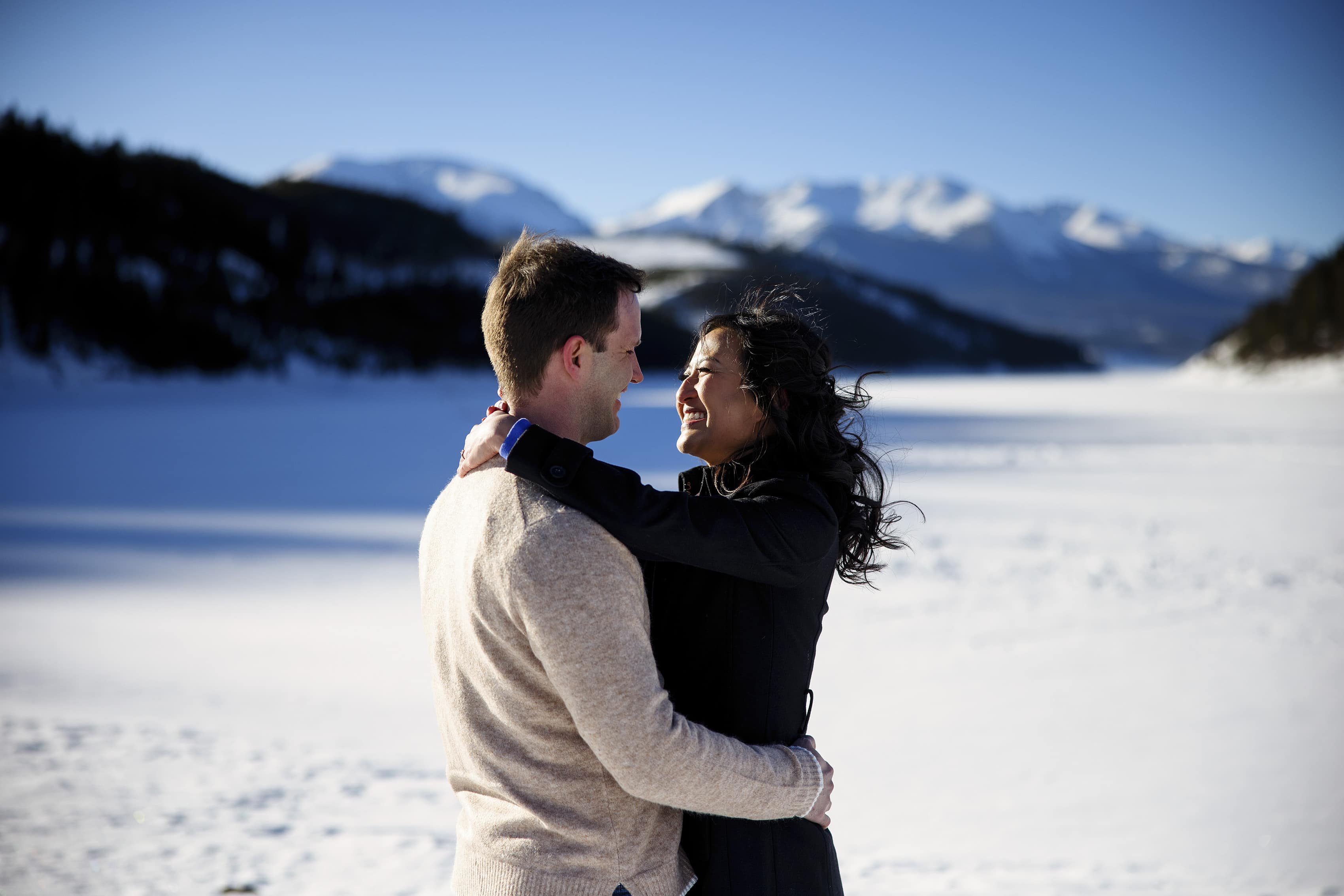 Nicole and Brett embrace on the ice at Dillon Reservoir during their engagment session