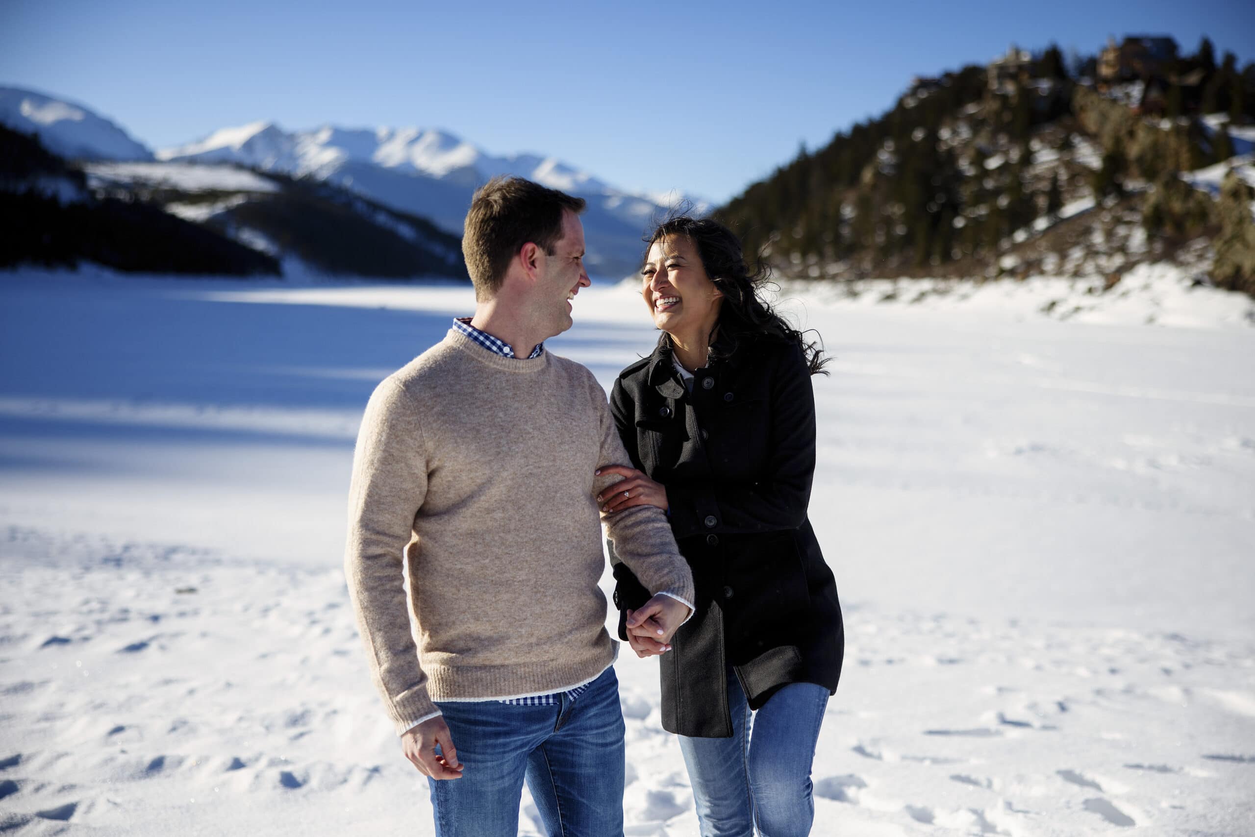 A couple shares a laugh in the snow at Dillon Reservoir