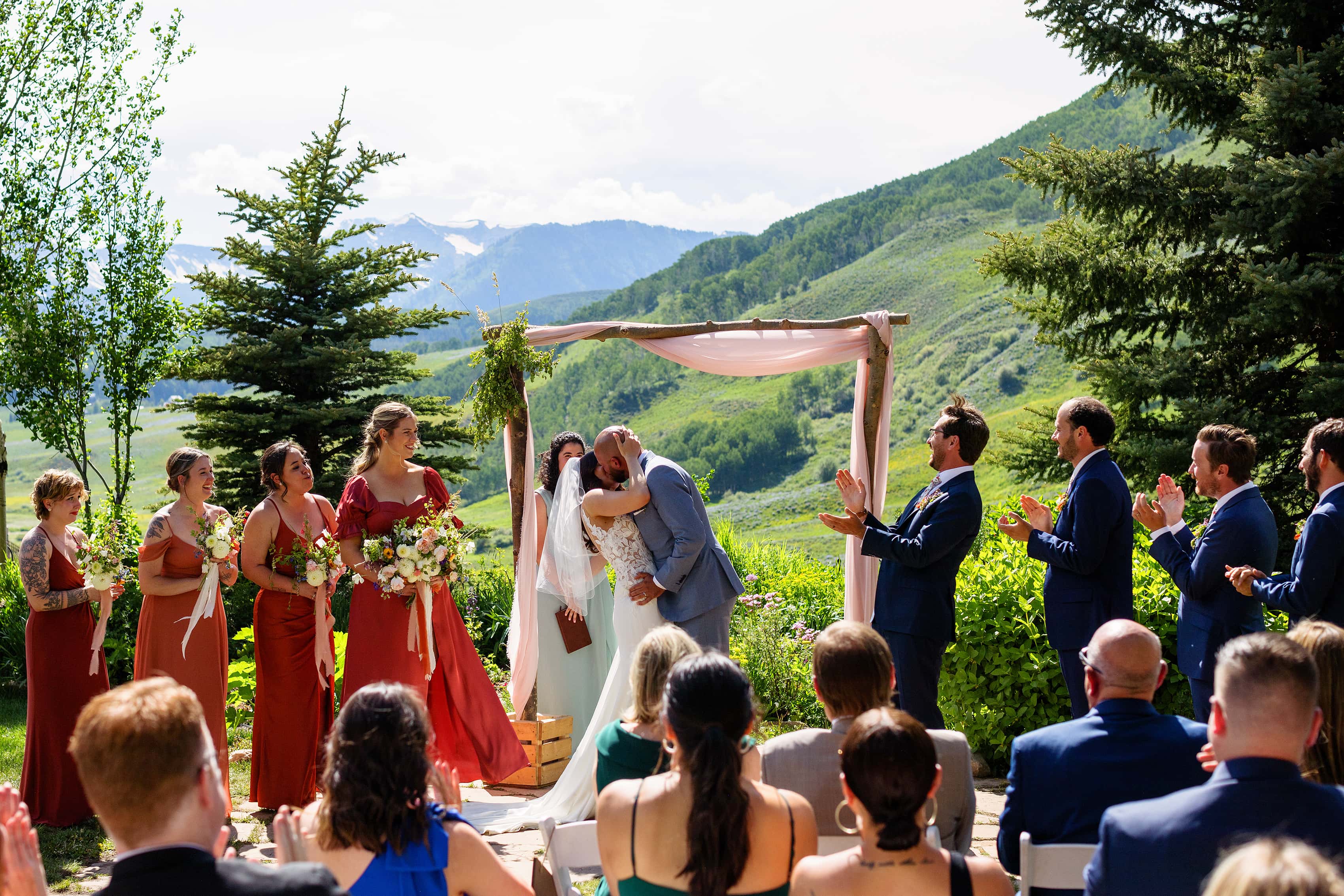 The newlyweds share their first kiss during their Mountain Wedding Garden ceremony in Crested Butte