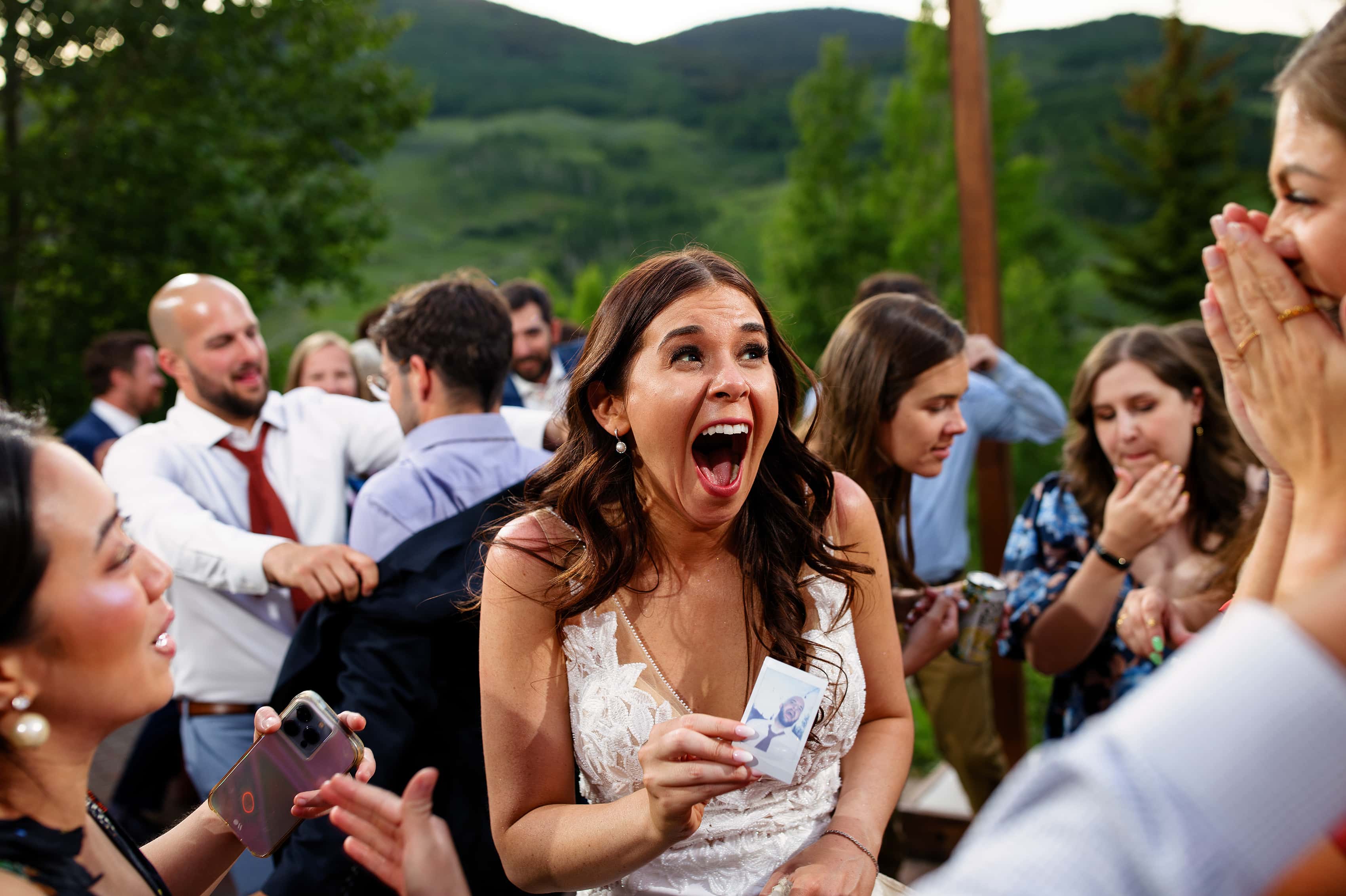 The bride reacts after taking a polaroid of the groom