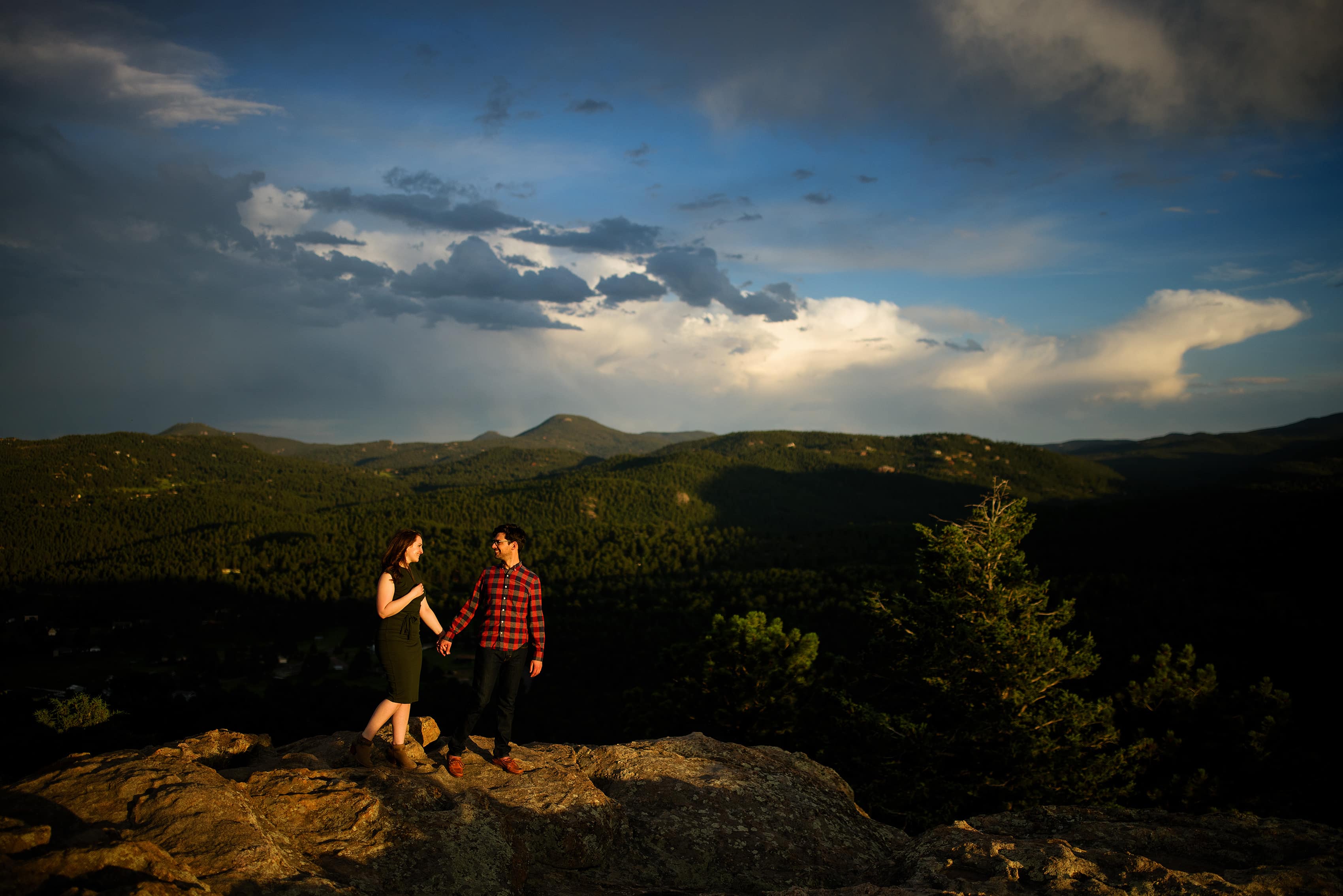 A couple walk together holding hands on Brothers Lookout in Evergreen